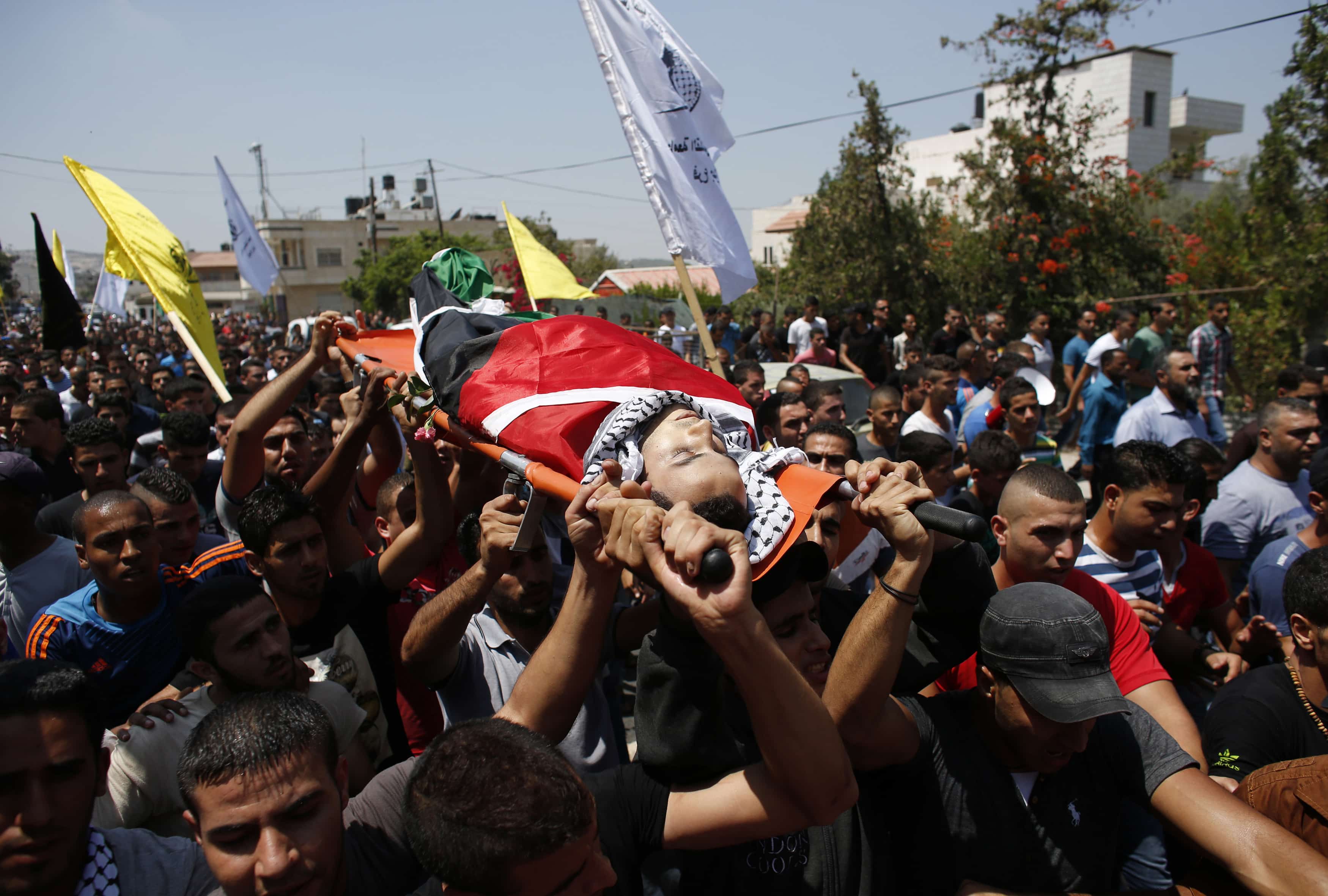 Palestinians carry the body of Maged Lahlouh during his funeral in Jenin refugee camp on 20 August 2013, REUTERS/Abed Omar Qusini