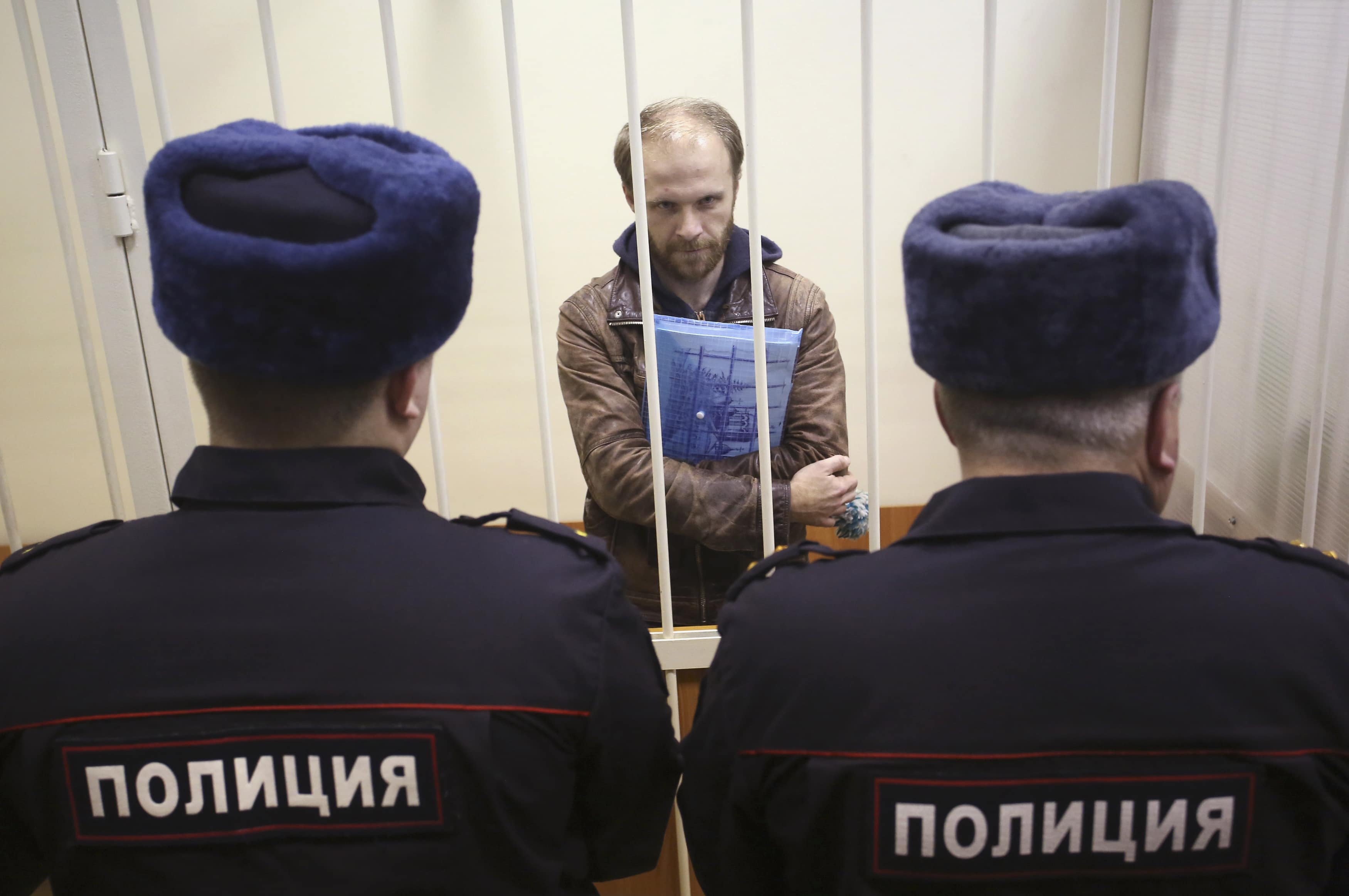 Photographer Denis Sinyakov of Russia stands in a defendants' cage during a court session in St. Petersburg on 18 November 2013. Sinyakov is among 30 people arrested for a Greenpeace protest against offshore Arctic drilling, REUTERS/Maxim Zmeyev