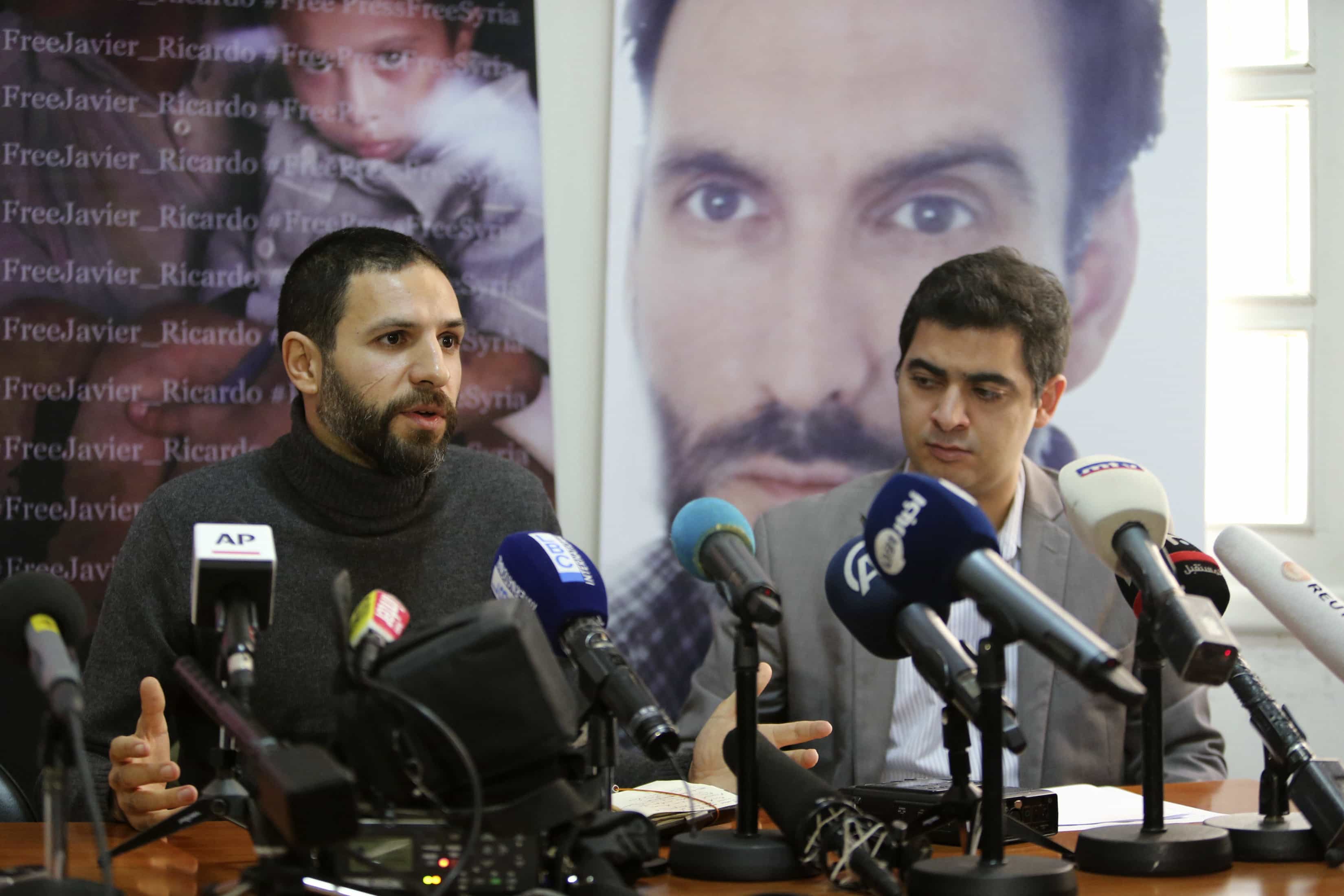 Correspondent Ghaith Abdul-Ahad (front L) and the Director of Samir Kassir Eyes Center for Media and Cultural Freedom Ayman Mhanna (front R) sit near the image of Spanish photographer Ricardo Garcia (R) as they speak during a news conference in Beirut on 10 December, REUTERS/Hasan Shaaban