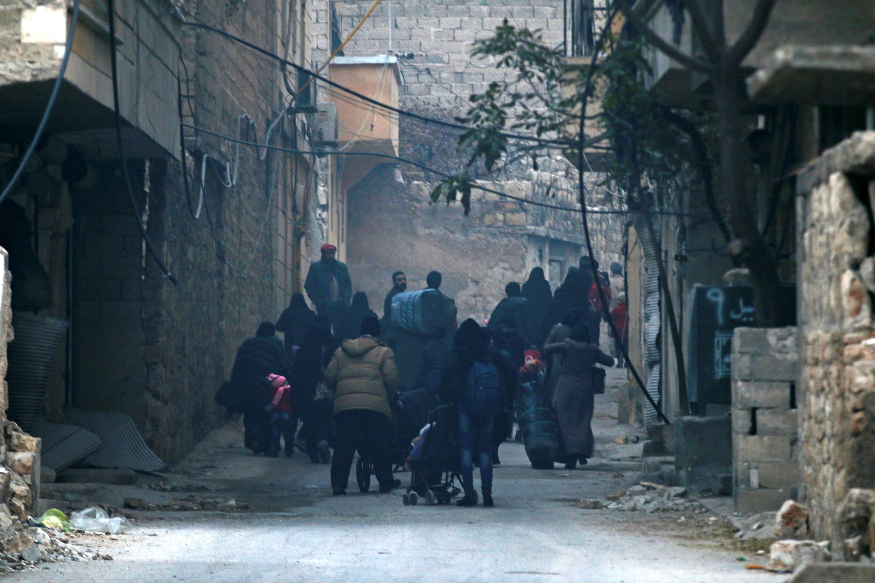 People carry belongings as they flee deeper into the remaining rebel-held areas of Aleppo, Syria December 12, 2016. , REUTERS/Abdalrhman Ismail