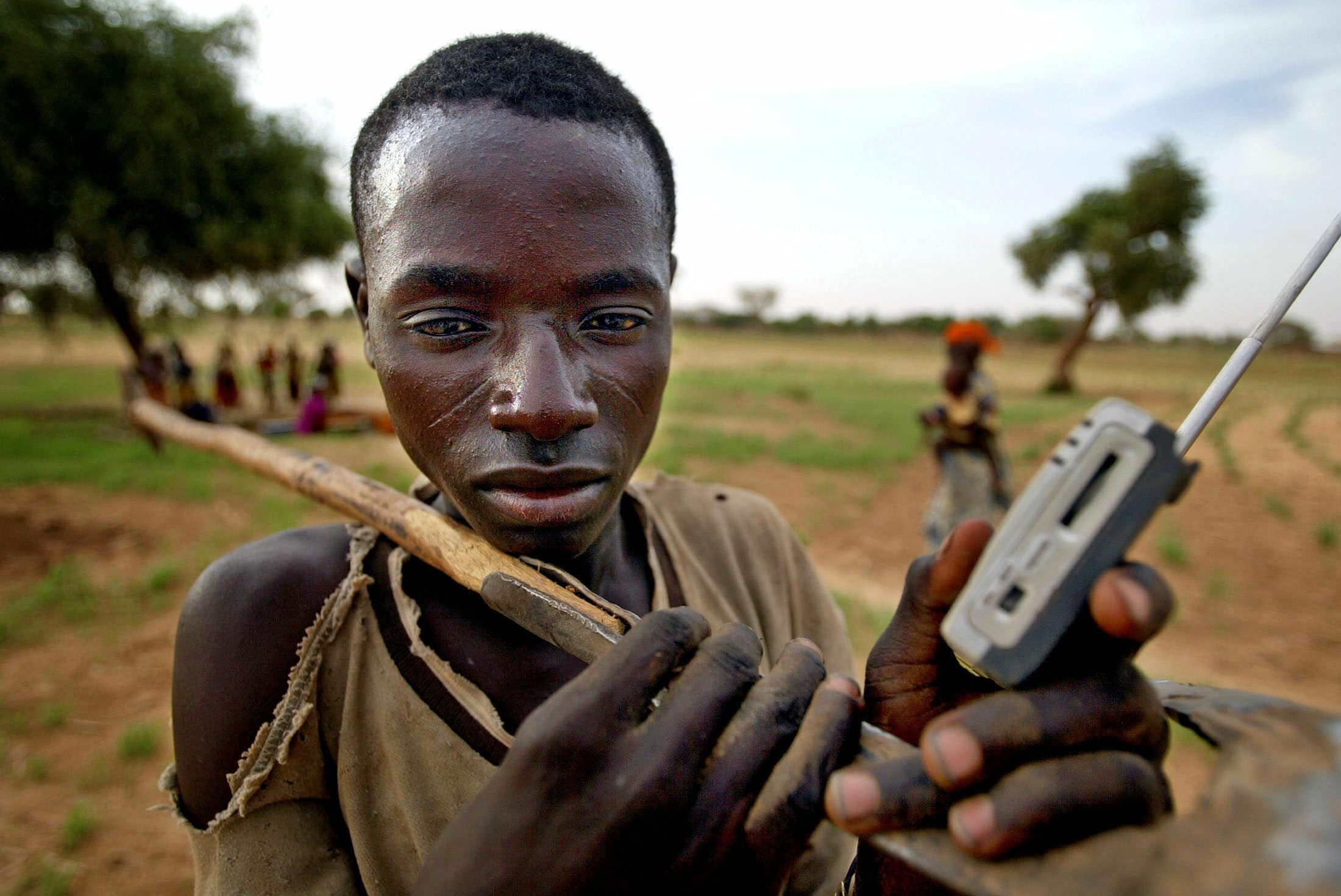 A farmer listens to his transistor radio as he returns home from work near the village of Koumboula in southern Niger June 30, 2005., REUTERS/Finbarr O'Reilly