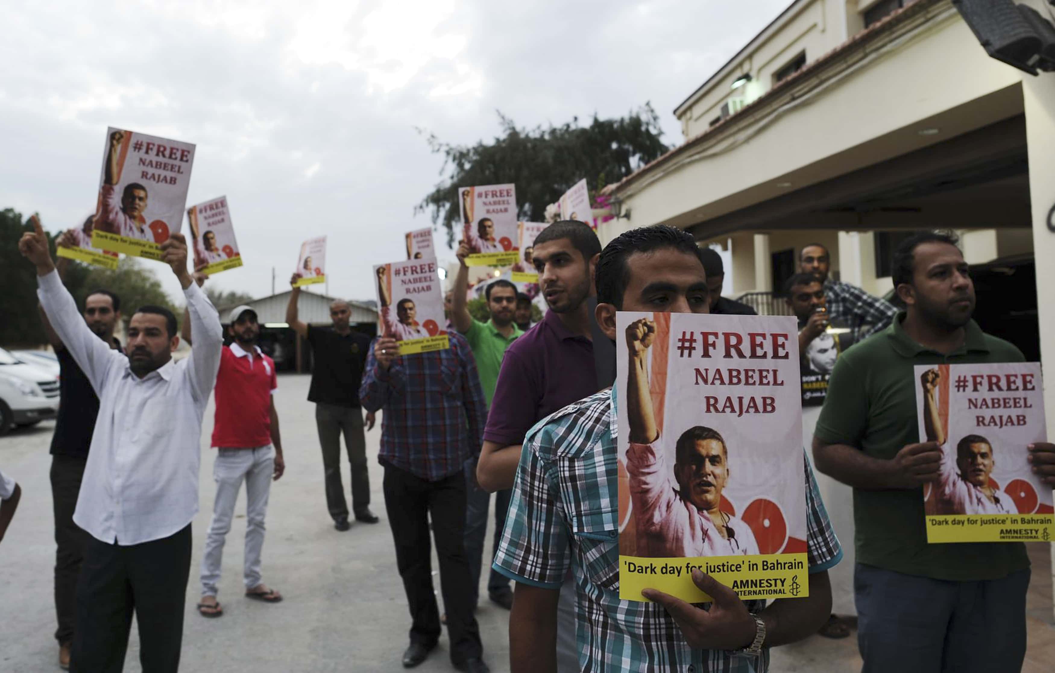 Protesters hold posters with an image of Nabeel Rajab during a protest outside his home west of Manama on 23 March 2013 as part of week long activities held in solidarity with the jailed rights defender, REUTERS/Stringer