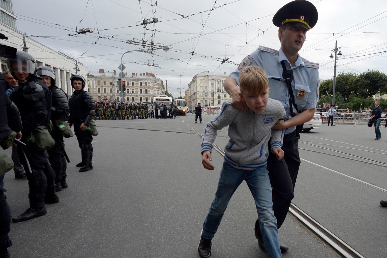 A Russian police officer apprehends a youth during a protest rally against planned increases to the nationwide pension age in Saint Petersburg, 9 September 2018, OLGA MALTSEVA/AFP/Getty Images