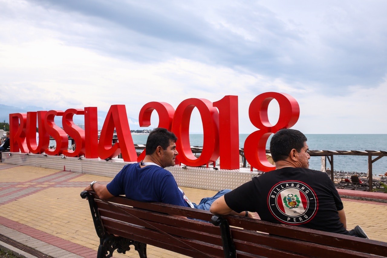 Football fans sit on a bench on Adler Beach prior to a 2018 FIFA World Cup Russia match in Sochi, Russia, 23 June 2018, Robbie Jay Barratt - AMA/Getty Images