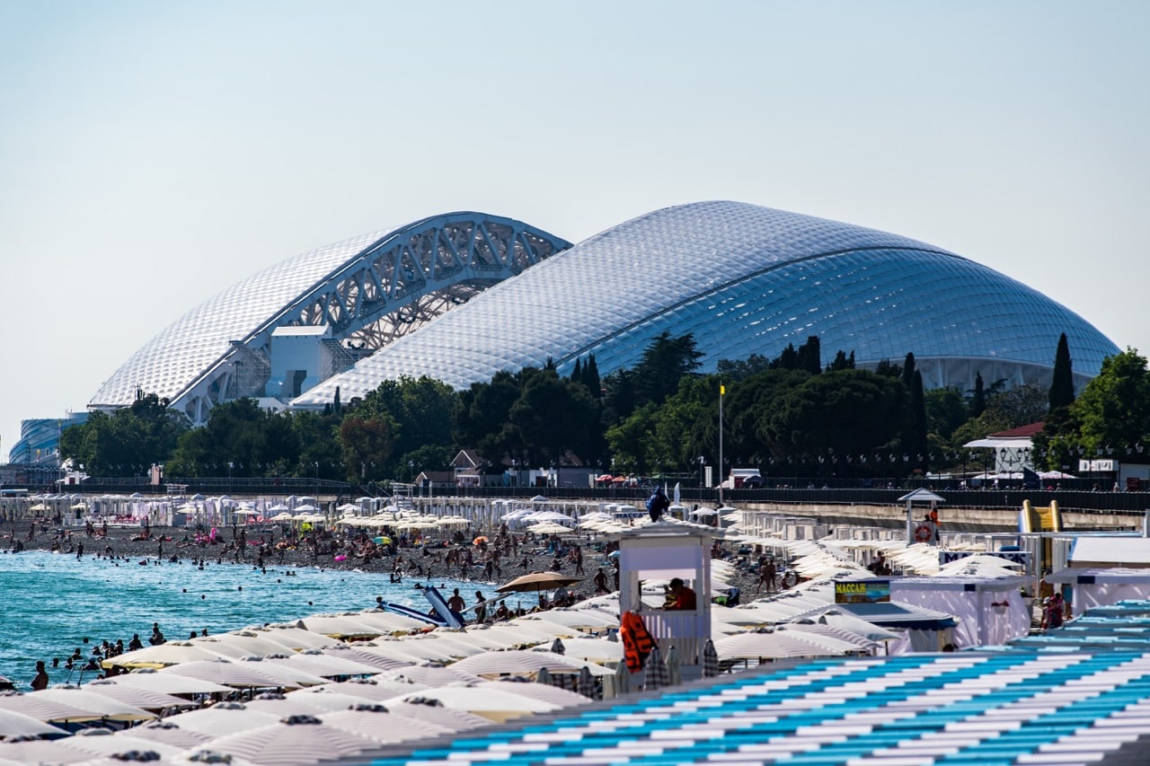 Tourists enjoy the the beach on the Black Sea with a view to the Fisht Stadium in Sochi, Russia, 28 June 2017, Lukas Schulze - FIFA/FIFA via Getty Images