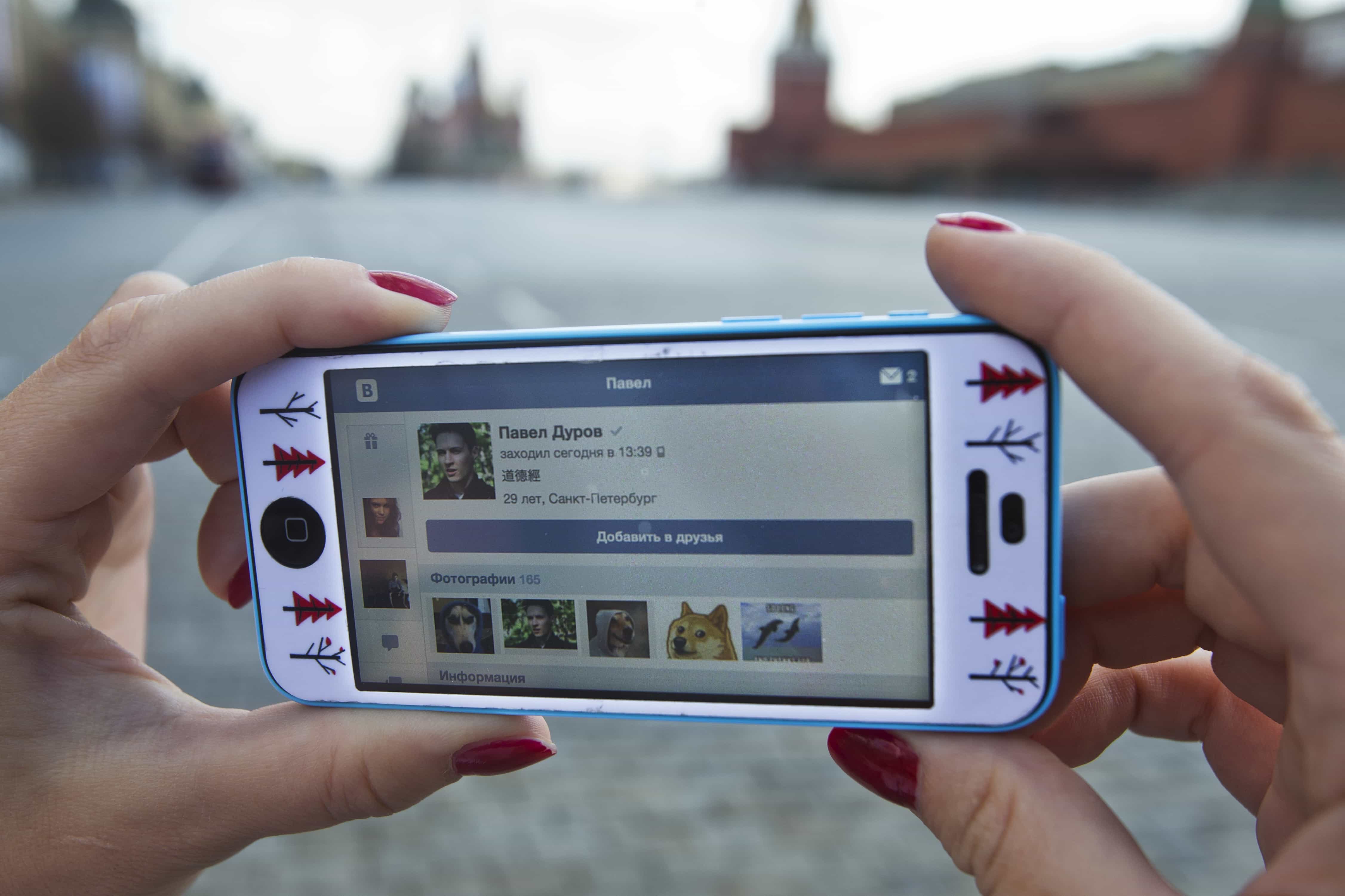 A user of Russia’s leading social network internet site VKontakte, poses holding an iPhone in Moscow, 23 April 2014., AP Photo/Pavel Golovkin