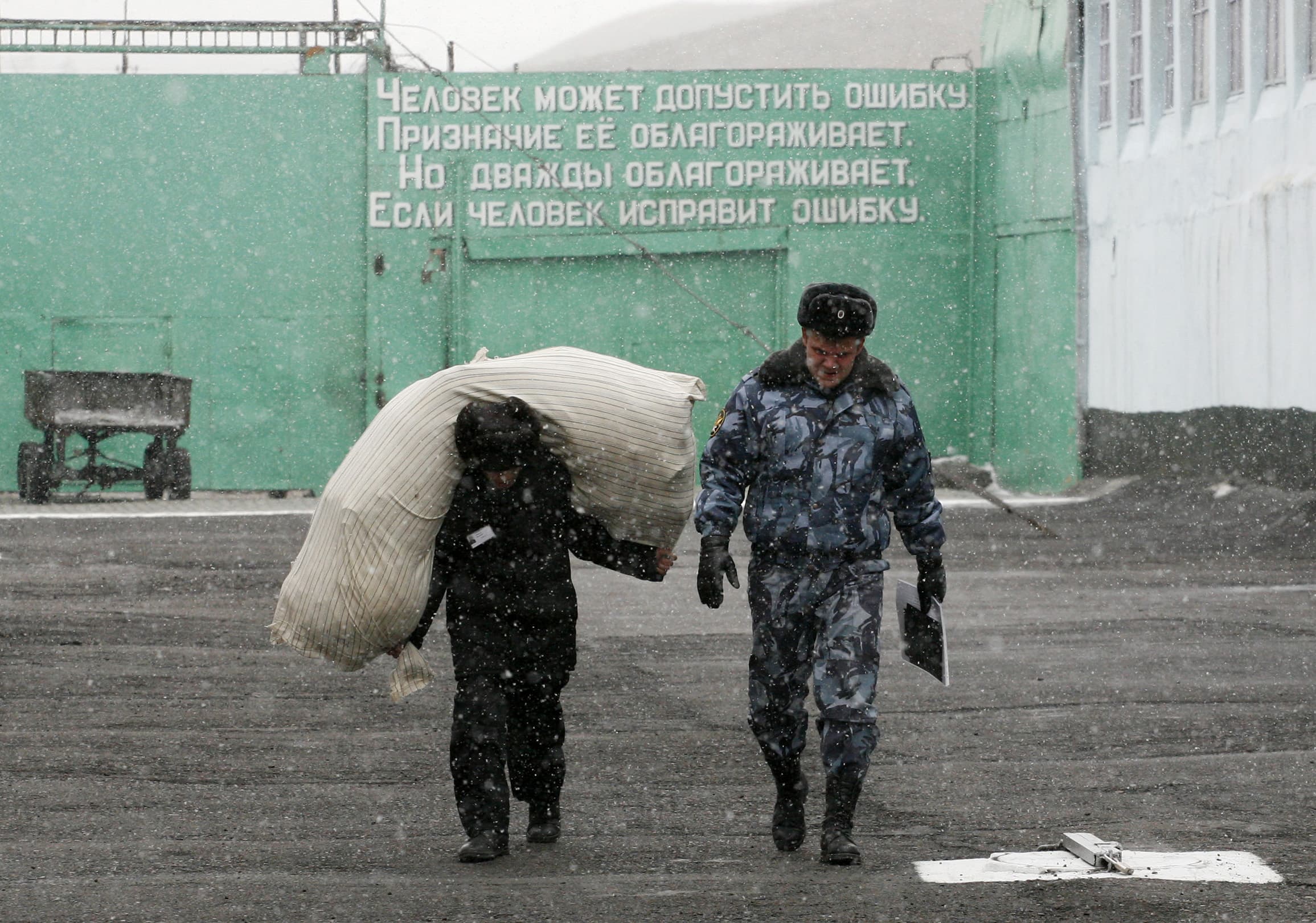 An inmate carries a sack at a male prison camp outside Russia's Siberian city of Krasnoyarsk 22 March, 2012. , REUTERS/Ilya Naymushin