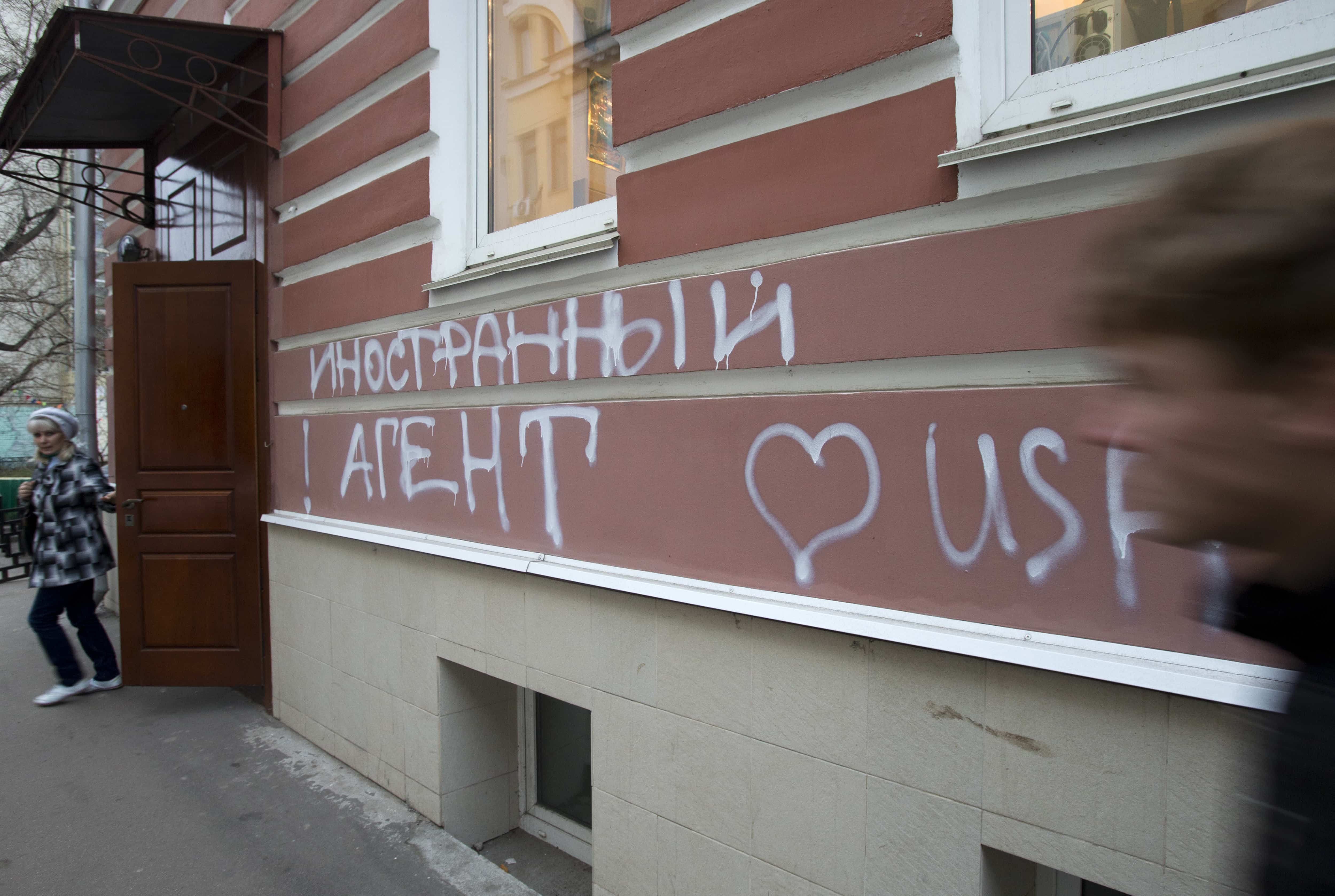 A man passes by the office of Memorial rights group in Moscow, on 21 November 2012. The building has the words “Foreign Agent (Loves) USA” spray-painted on its facade by unidentified people, AP Photo/Misha Japaridze