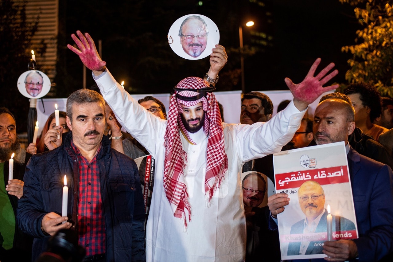 A protestor wears a mask depicting Saudi Crown Prince Mohammad Bin Salman while others hold images of journalist Jamal Khashoggi during a demonstration outside the Saudi Arabia consulate in Istanbul, Turkey, 25 October 2018, YASIN AKGUL/AFP/Getty Images