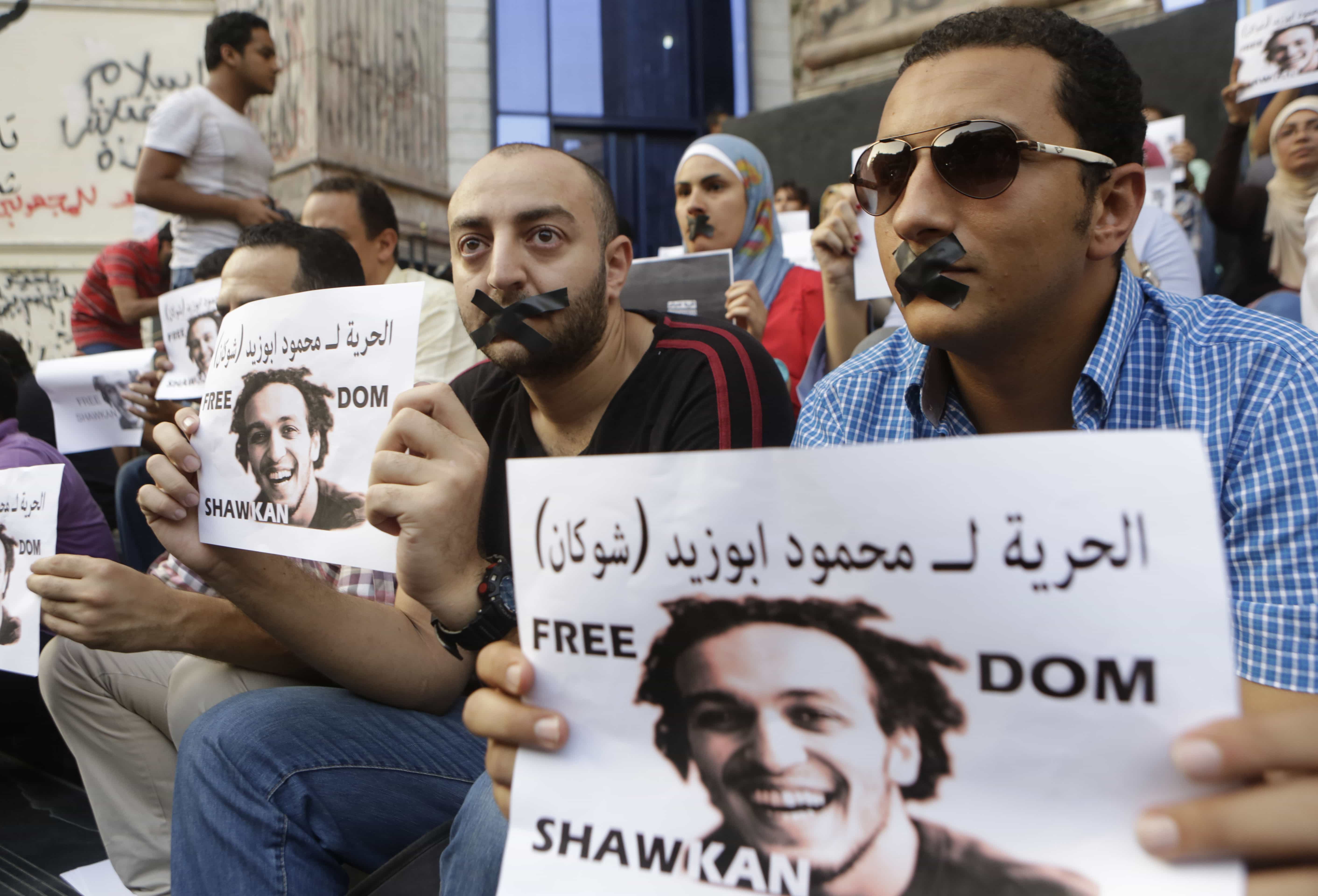 Egyptian journalists tape their mouths and hold signs during a 2014 protest , AP Photo/Amr Nabil, File