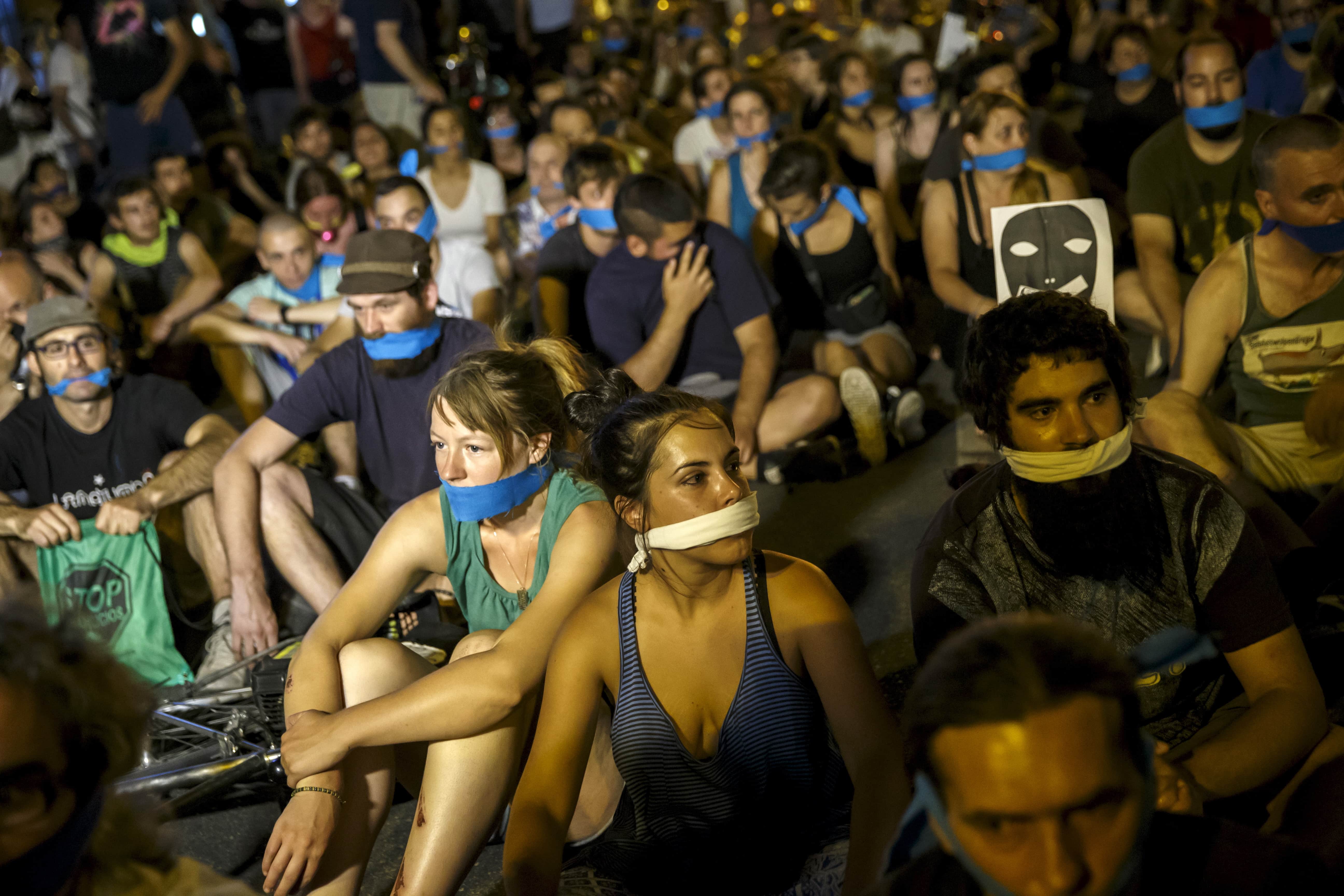 Demonstrators sit outside the Spanish parliament during a protest against the new security law, in Madrid, 1 July 2015, REUTERS/Juan Medina