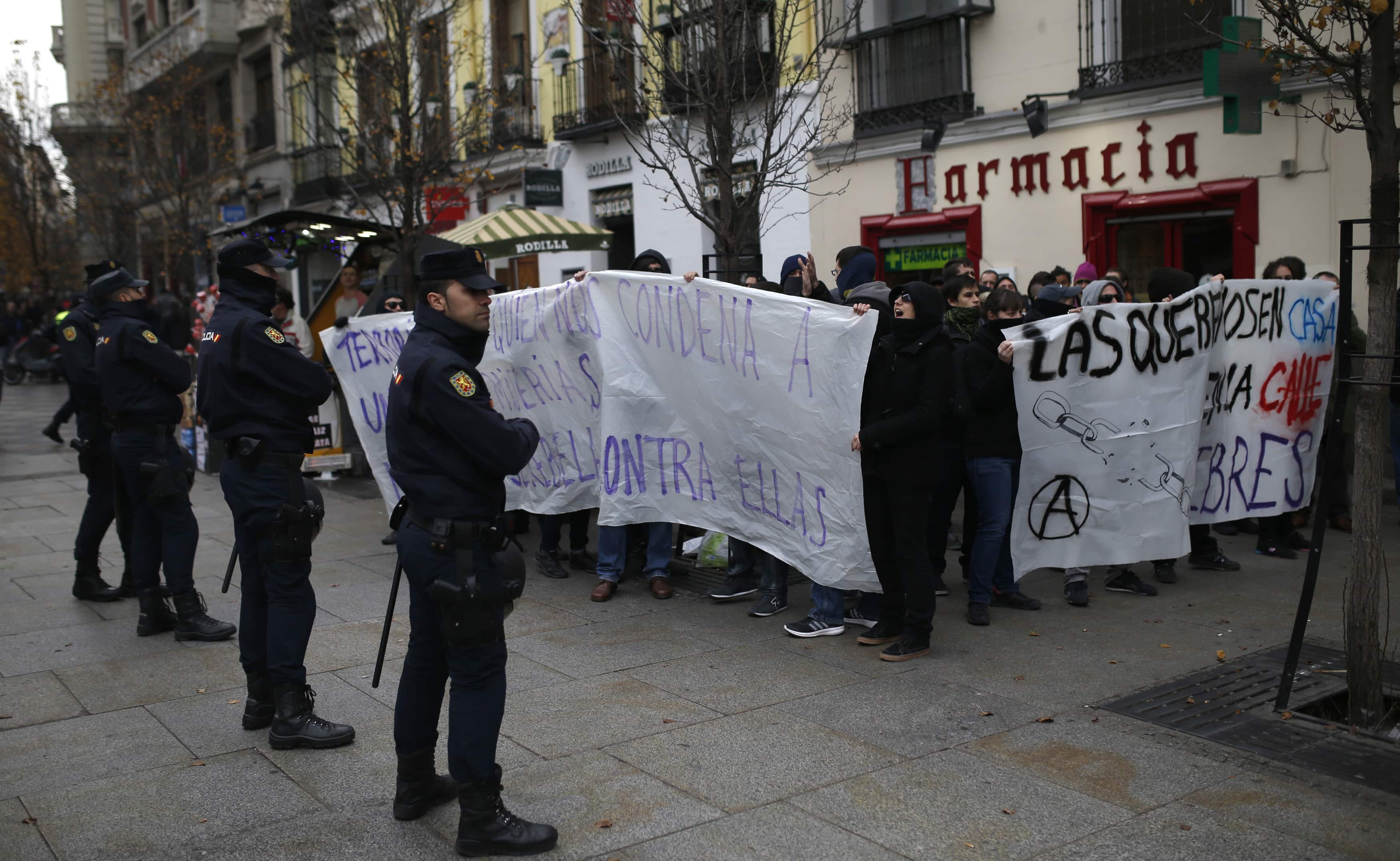 Police officers stand in front of demonstrators demanding the release of several anarchists and against the "Ley Mordaza" in Madrid, 27 December 2014, REUTERS/Javier Barbancho