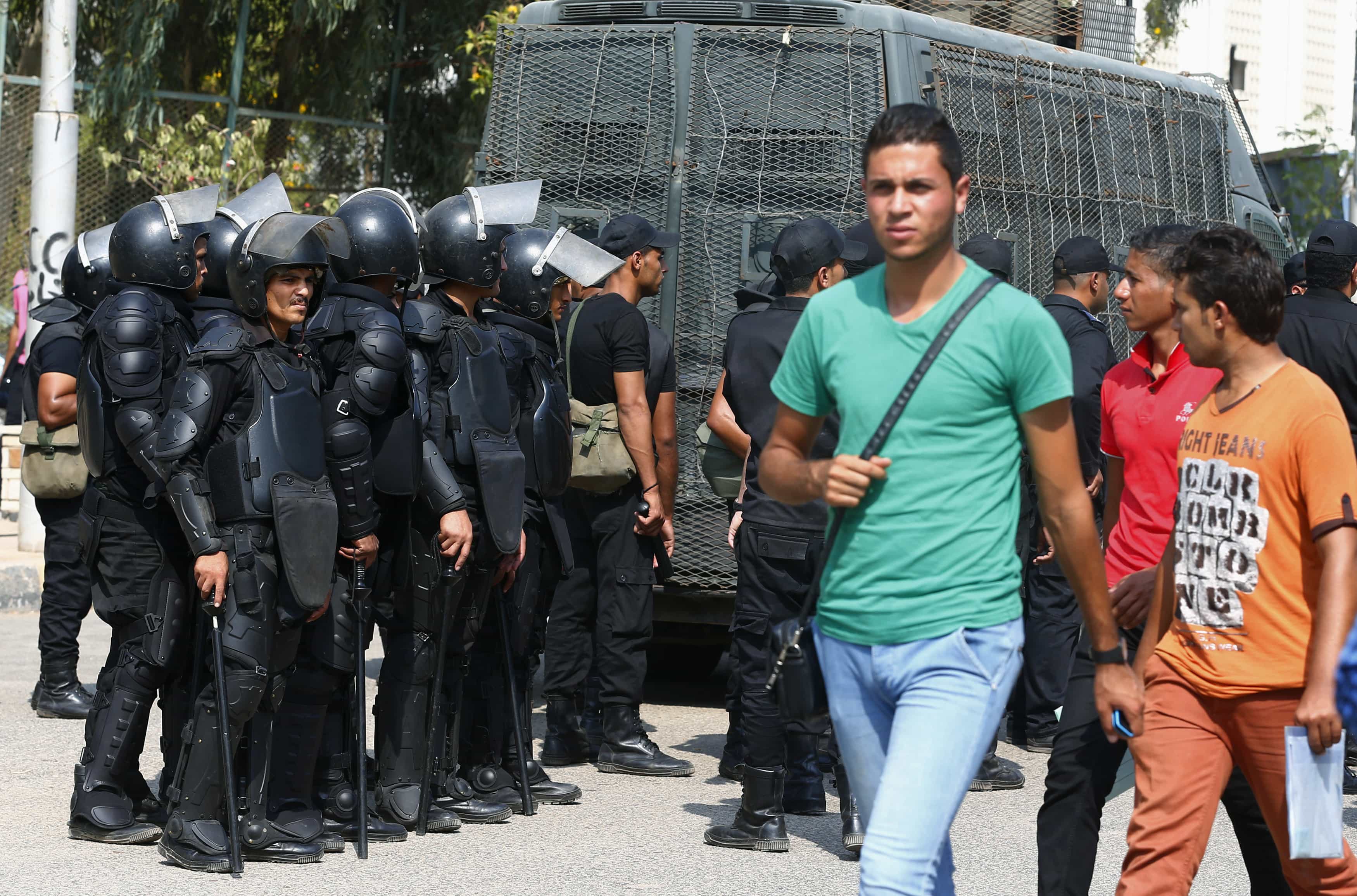 Al-Azhar University students walk past riot police during a protest conducted by a pro-Muslim Brotherhood student movement in Nasr City district on 12 October 2014,  REUTERS/Amr Abdallah Dalsh