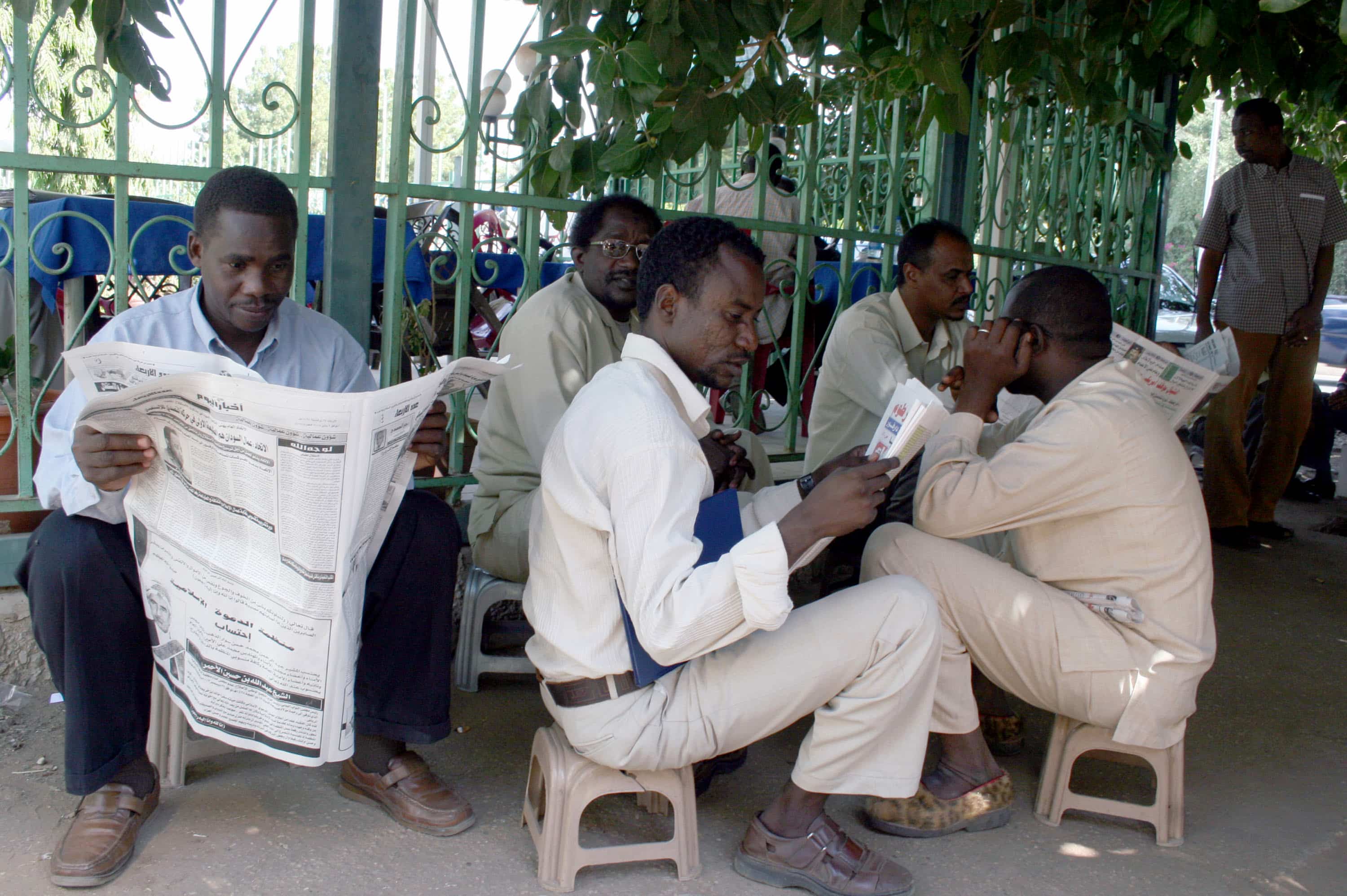 Sudanese men read newspapers on a street in Khartoum, Sudan, 2 January 2008., AP Photos / Abd Raouf