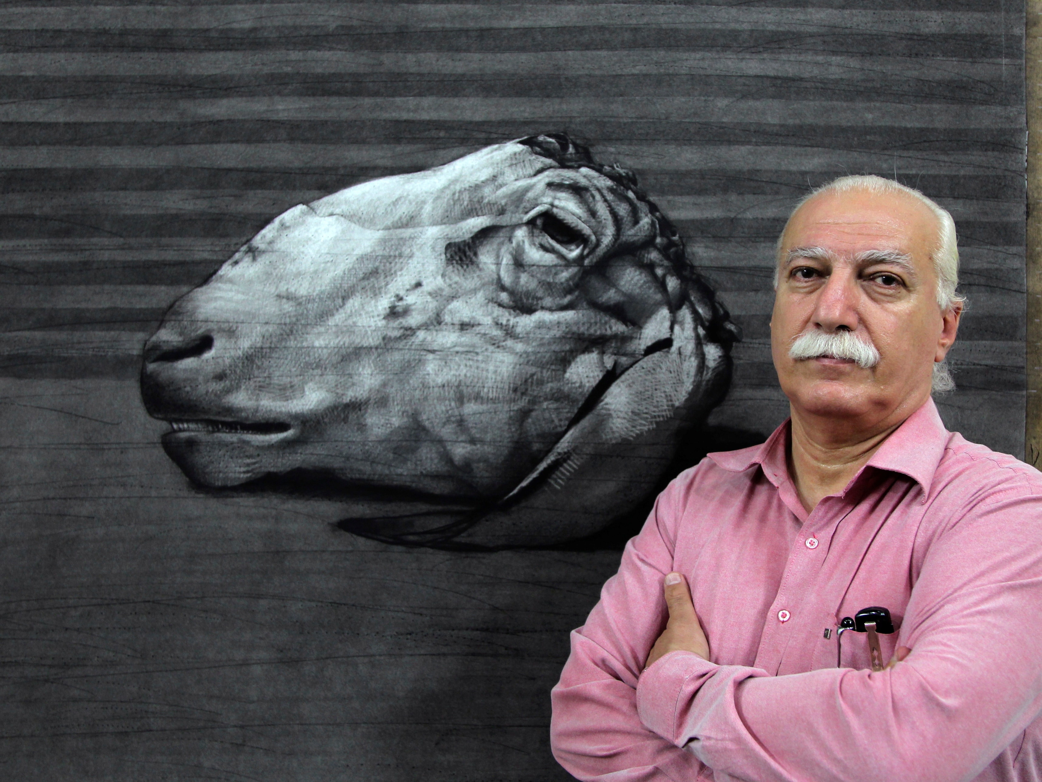 Syrian artist Youssef Abdelke stands in front of one of his works at his atelier in Damascus, 23 September 2010, REUTERS/Khaled al-Hariri