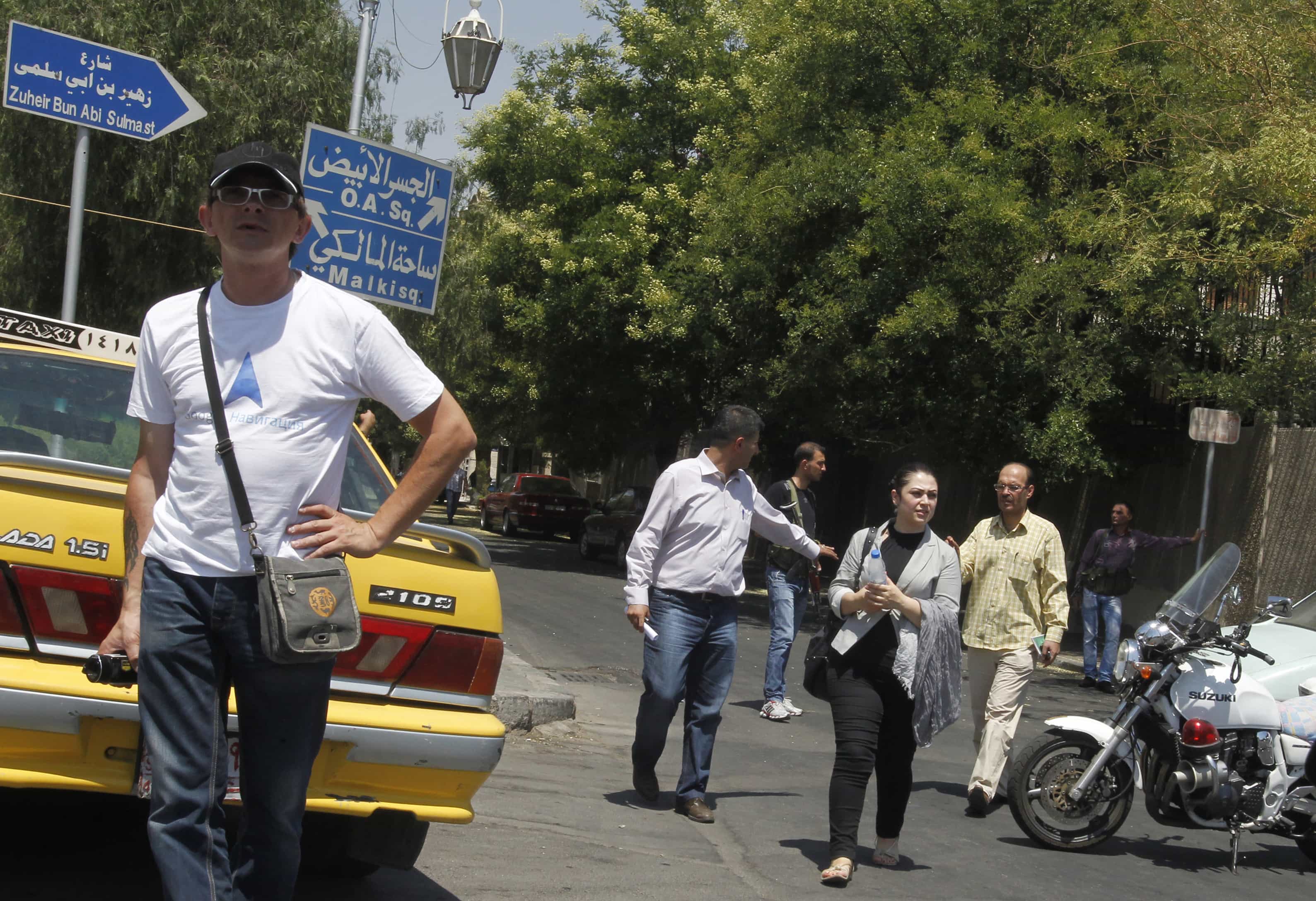 Journalists leave a road leading to the national security building after access to the area was blocked in Damascus on 18 July 2012, REUTERS/Khaled Al Hariri