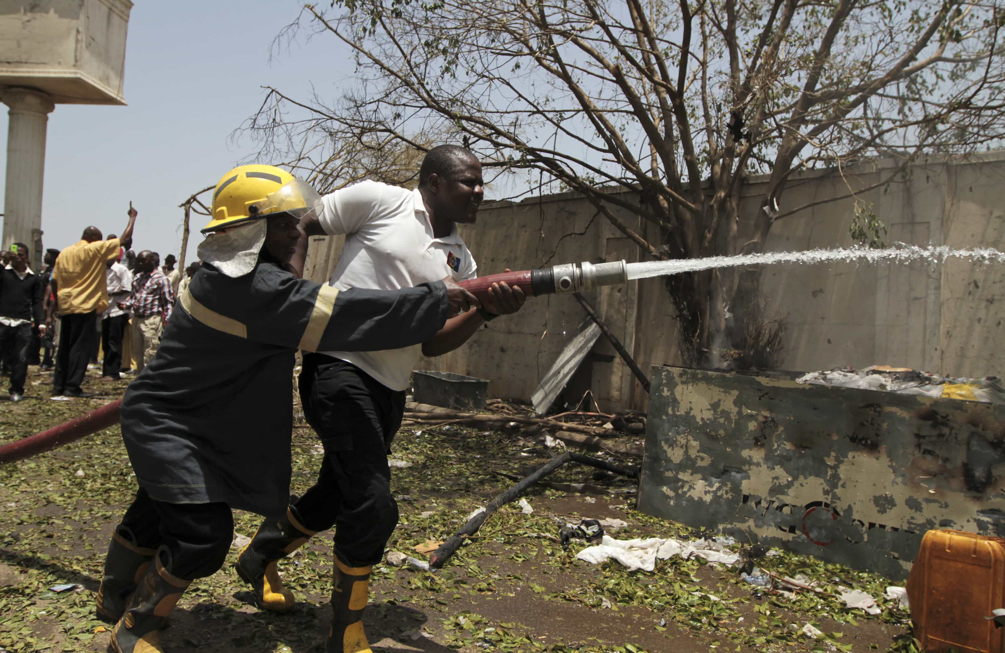 Firefighters drag a hose through the damaged building of Nigerian newspaper ThisDay after a bomb blast on its premises in Abuja 26 April 2012., REUTERS/Afolabi Sotunde