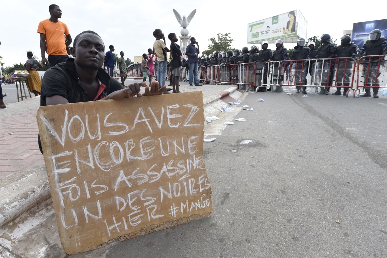 A protester holds a sign reading 'yesterday you once again assassinated one of ours, #mango', referring to a 9-year-old killed in Mango, northern Togo, 21 September 2017, PIUS UTOMI EKPEI/AFP/Getty Images