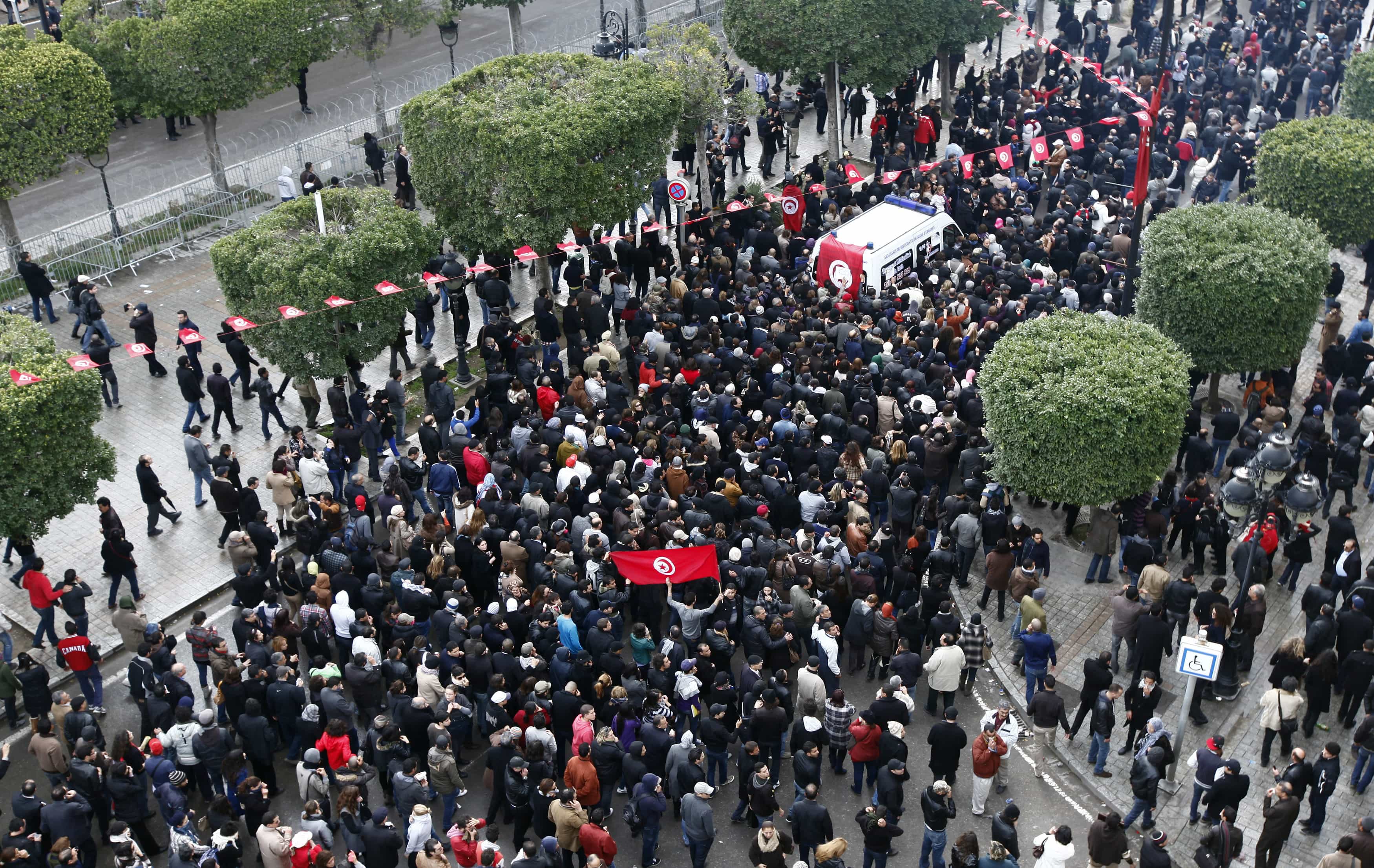 The body of Tunisian opposition figure Chokri Belaid (top R) arrives amidst tens of thousands of protesters as they demonstrate on Avenue Habib Bourguiba in Tunis on 6 February 2013, REUTERS/Anis Mili