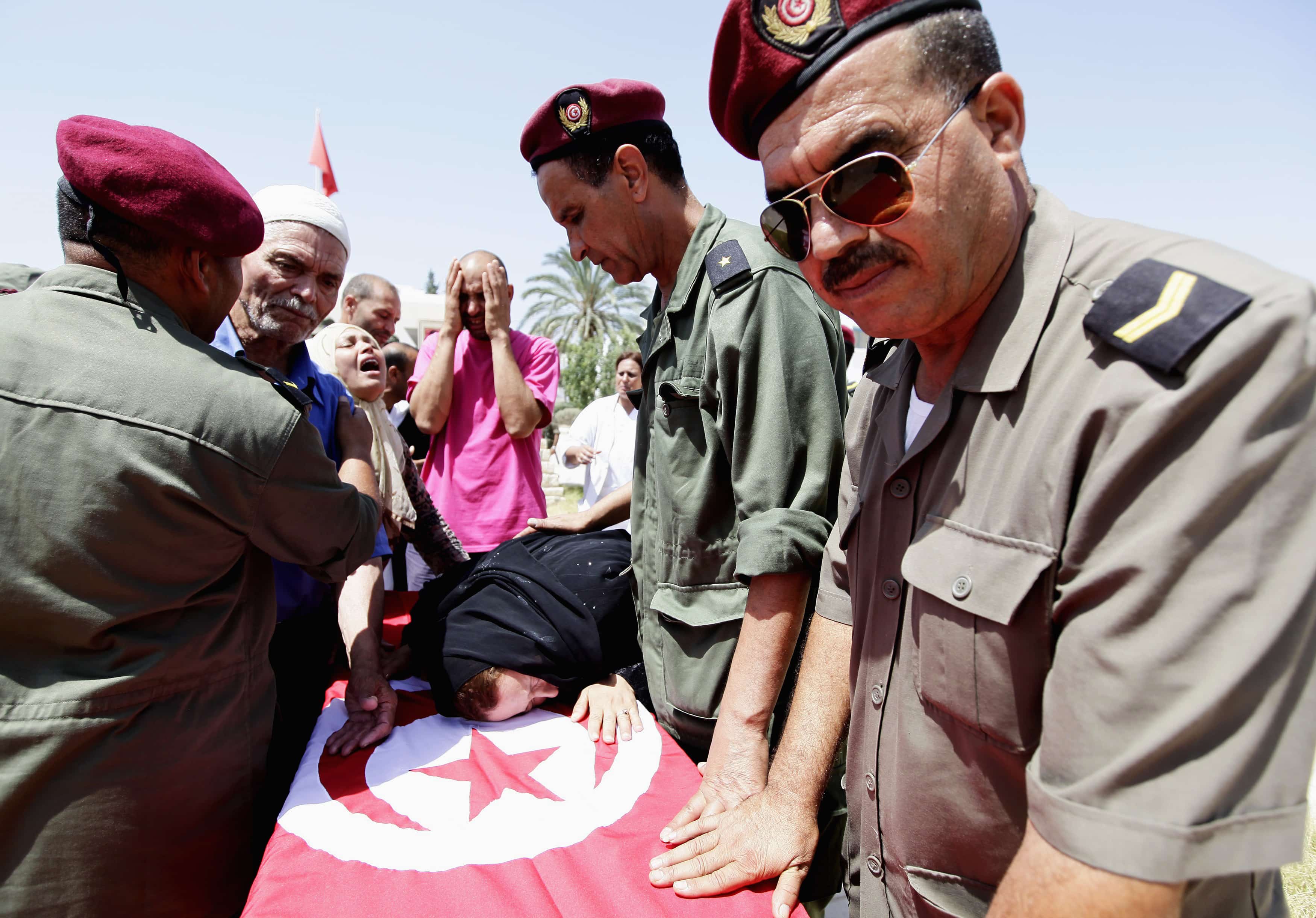 Family members and colleagues mourn near the coffin of Tunisian soldier Lamjid al-Arfaoui during his funeral, REUTERS/Anis Mili