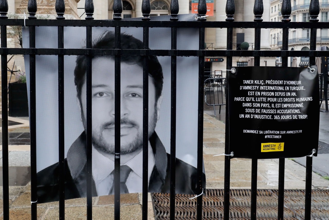 A portrait of Taner Kılıç, chair of Amnesty Turkey, is hung in front of a historic stock market building, in Paris, France, 6 June 2018; Kılıç was released on 15 August, FRANCOIS GUILLOT/AFP/Getty Images