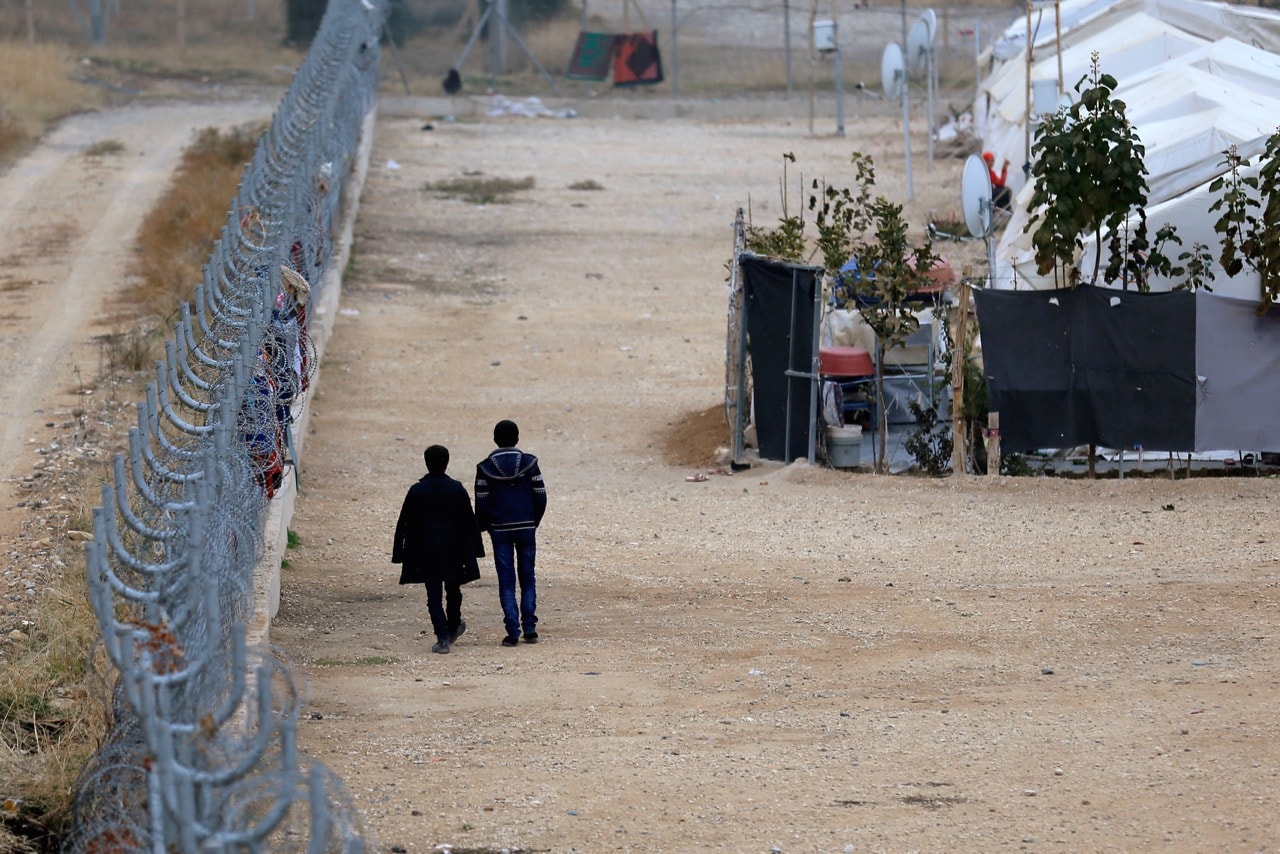 Two Syrian refugees walk along a fence in the Nizip refugee camp, near the Turkish-Syrian border in Gaziantep province, Turkey, 30 November 2016, REUTERS/Umit Bektas