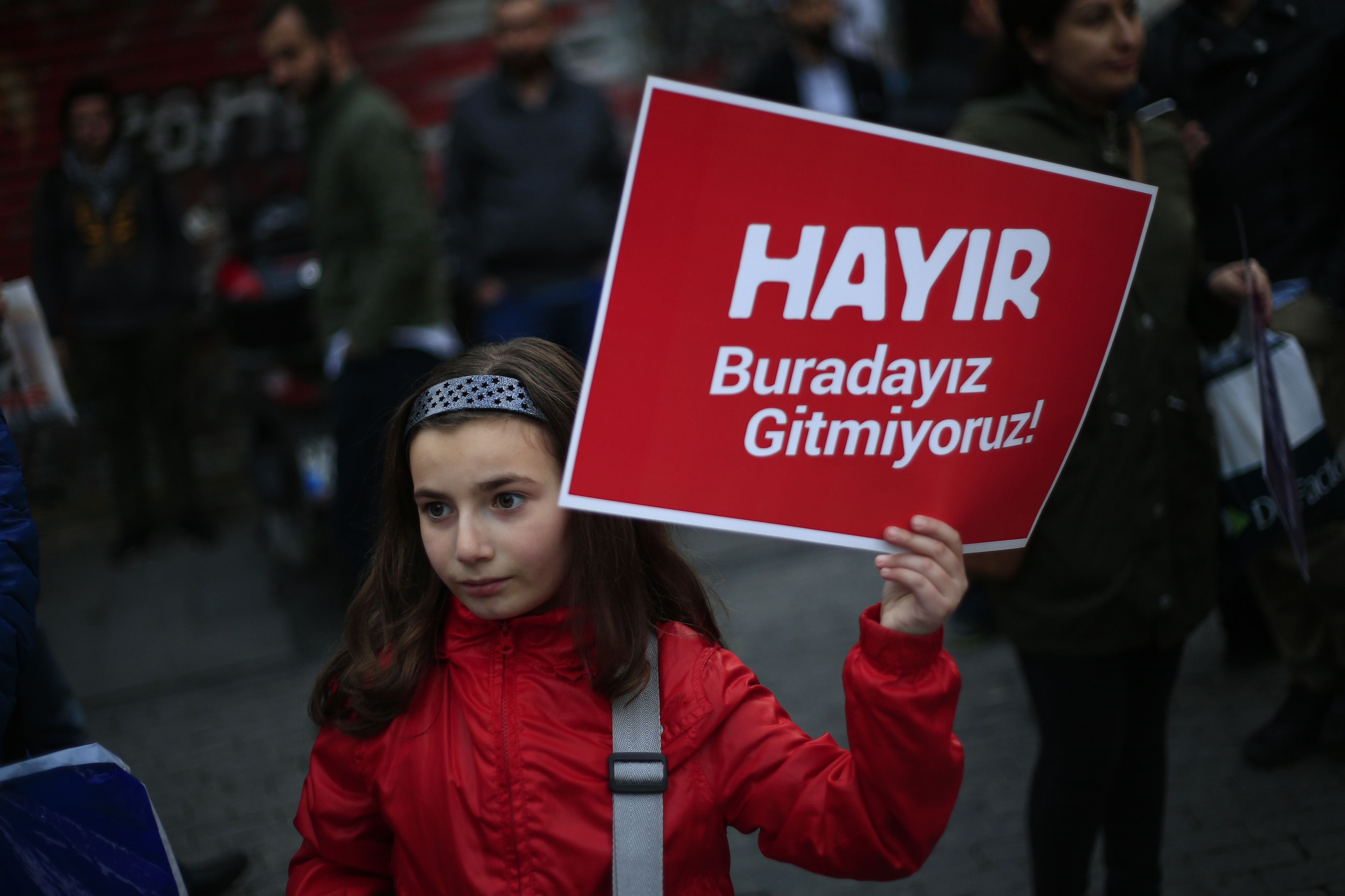 Istanbul le 21 avril 2017. Pendant une manifestation des partisans du « NON » contre le résultat du referendum, une fille porte une pancarte sur laquelle on peut lire: " NON, nous sommes ici, nous n'allons partir nulle part", AP Photo/Lefteris Pitarakis