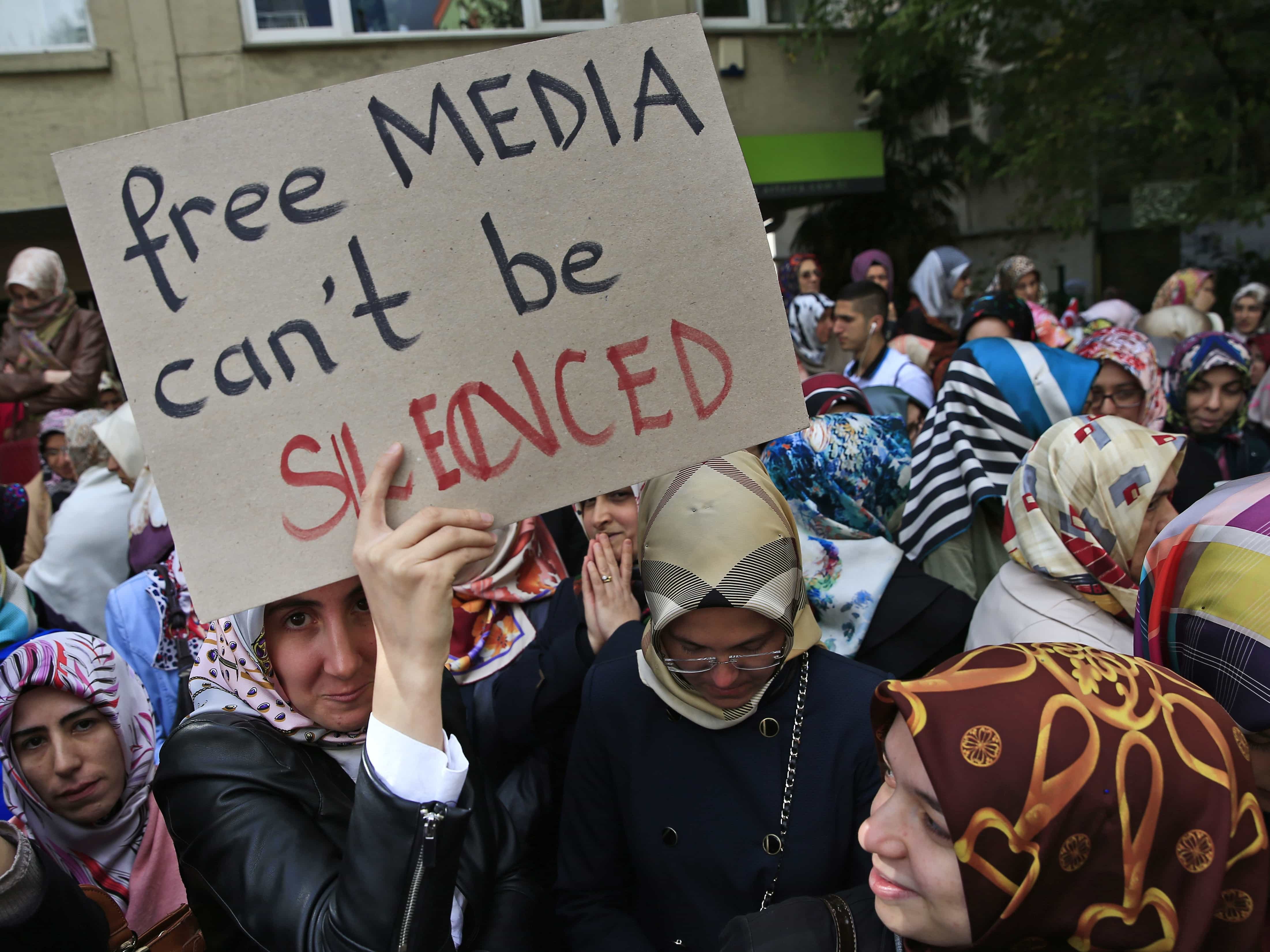 Protesters holding placards demonstrate across the street from the headquarters of a media company in central Istanbul, 28 October 2015, AP Photo/Lefteris Pitarakis