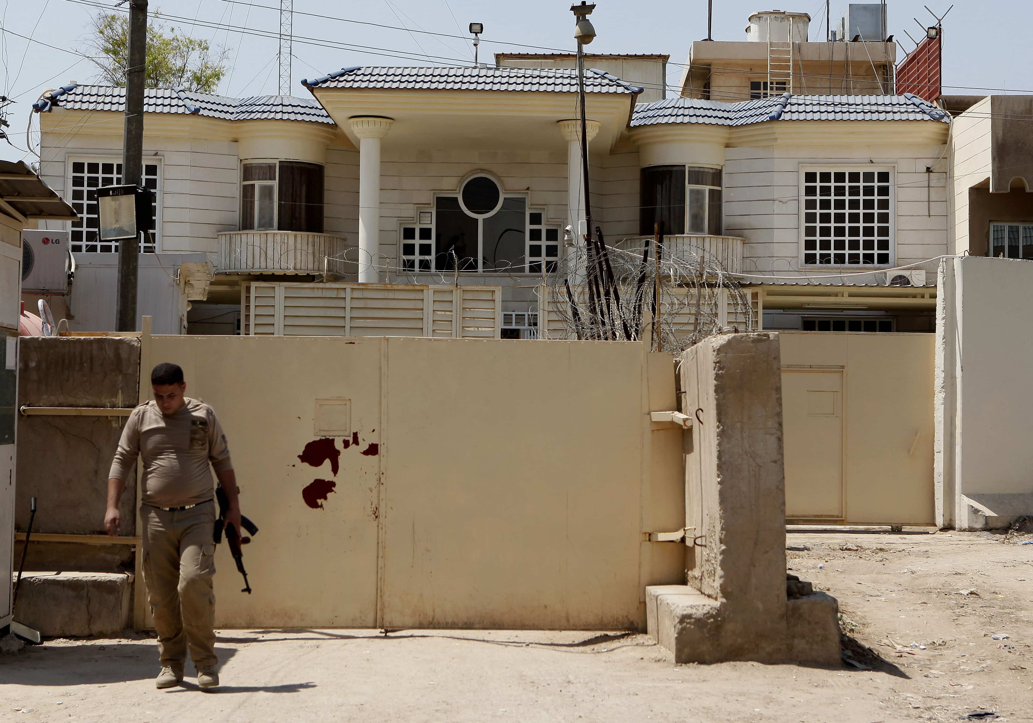 A private security guard stands guard at al-Jazeera's headquarters in Baghdad, Iraq on 29 April 2013, AP Photo/Hadi Mizban