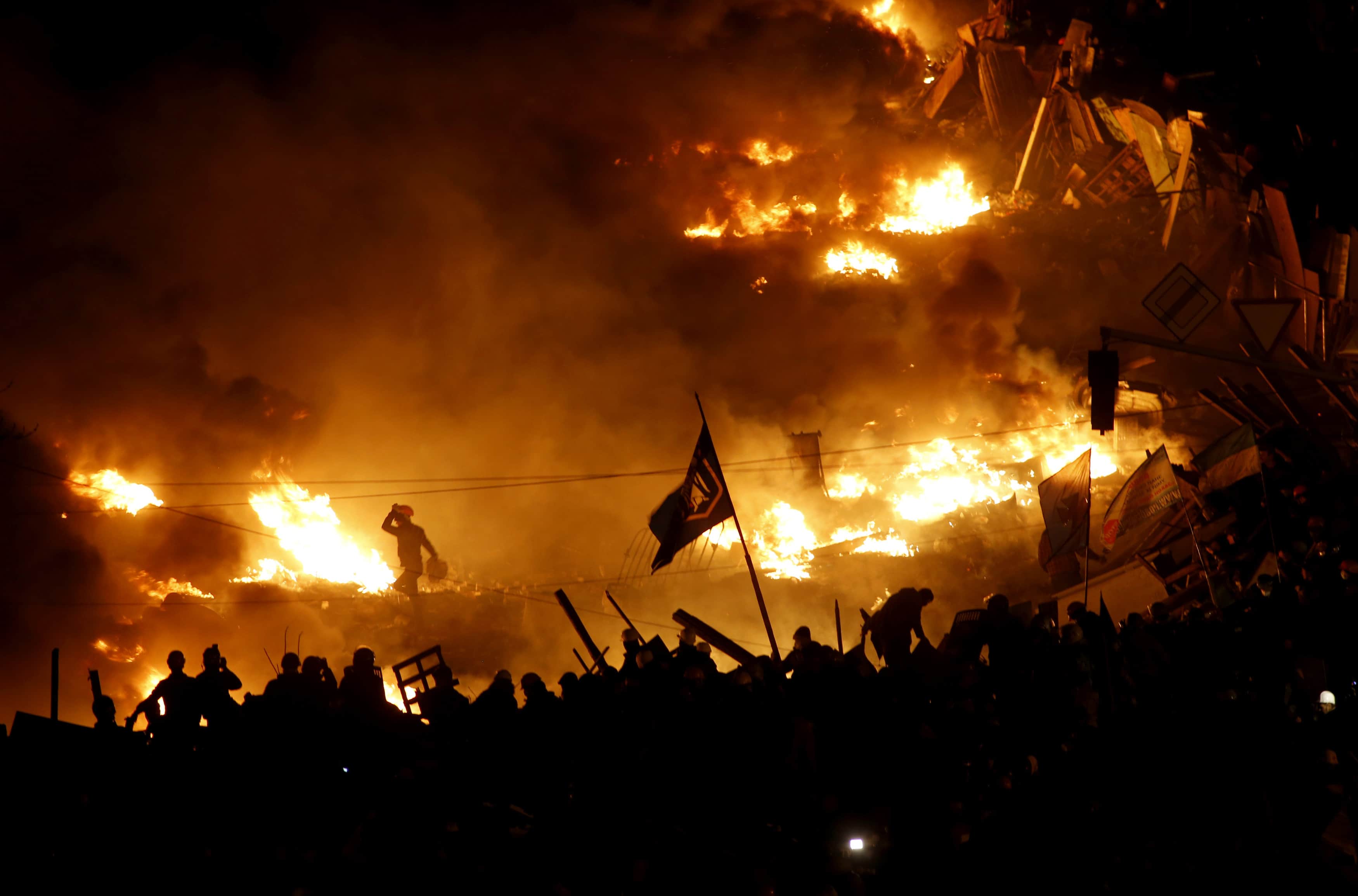 Anti-government protesters stand behind burning barricades in Kiev's Independence Square, 19 February 2014., REUTERS/Vasily Fedosenko