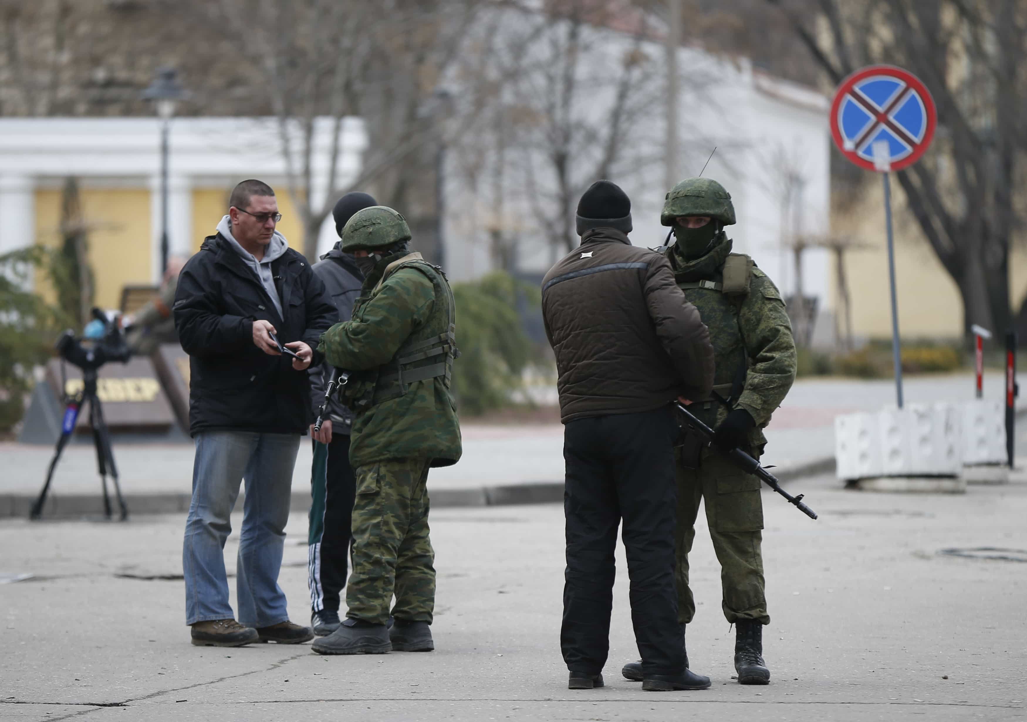 Armed men check journalists' documents around the regional Parliament building in the Crimean city of Simferopol, 1 March 2014., REUTERS/David Mdzinarishvili