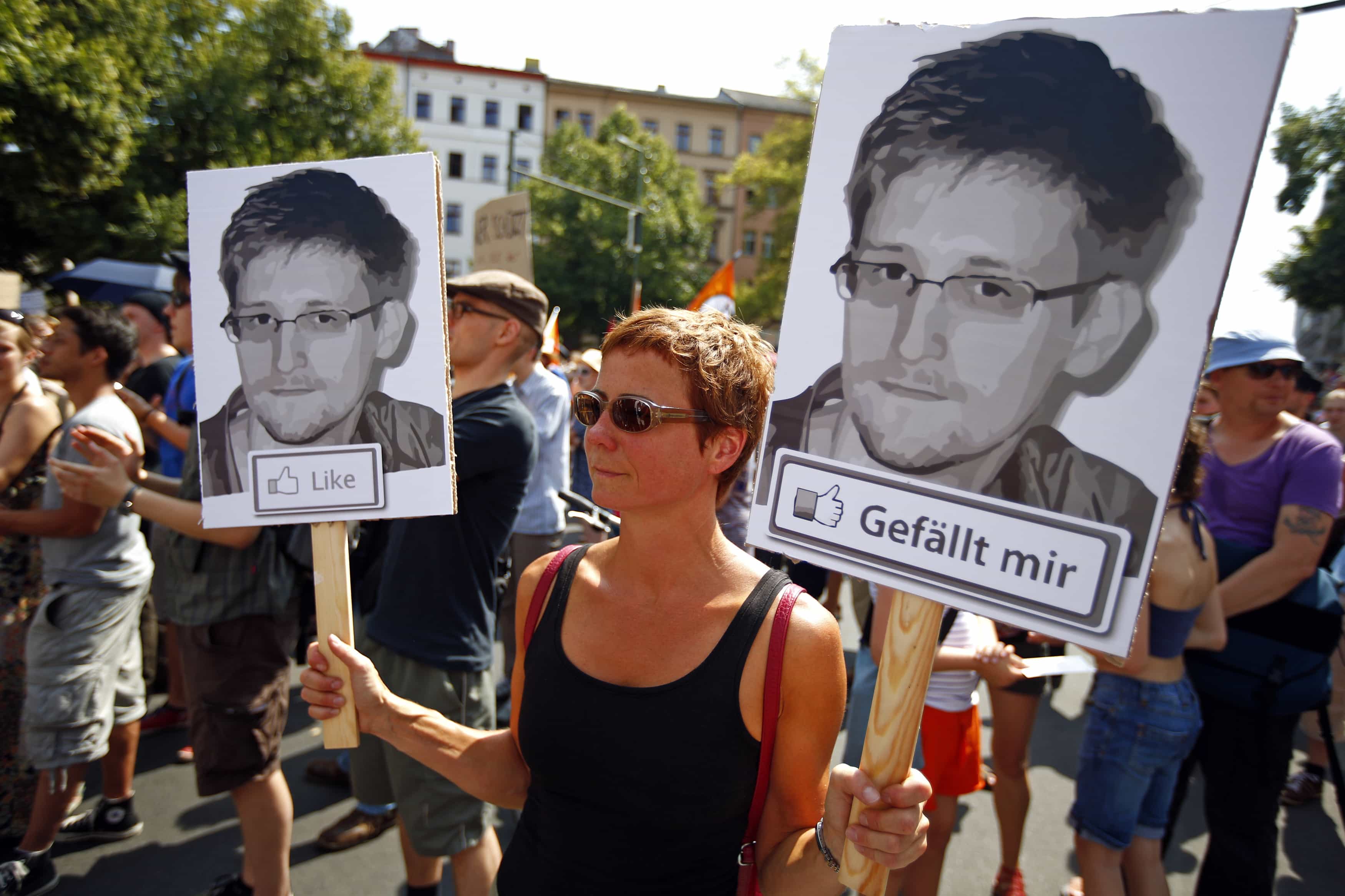 A protester carries portraits of Edward Snowden during a demonstration against secret monitoring programmes and showing solidarity with whistleblowers Edward Snowden and others in Berlin on 27 July 2013, REUTERS/Pawel Kopczynski