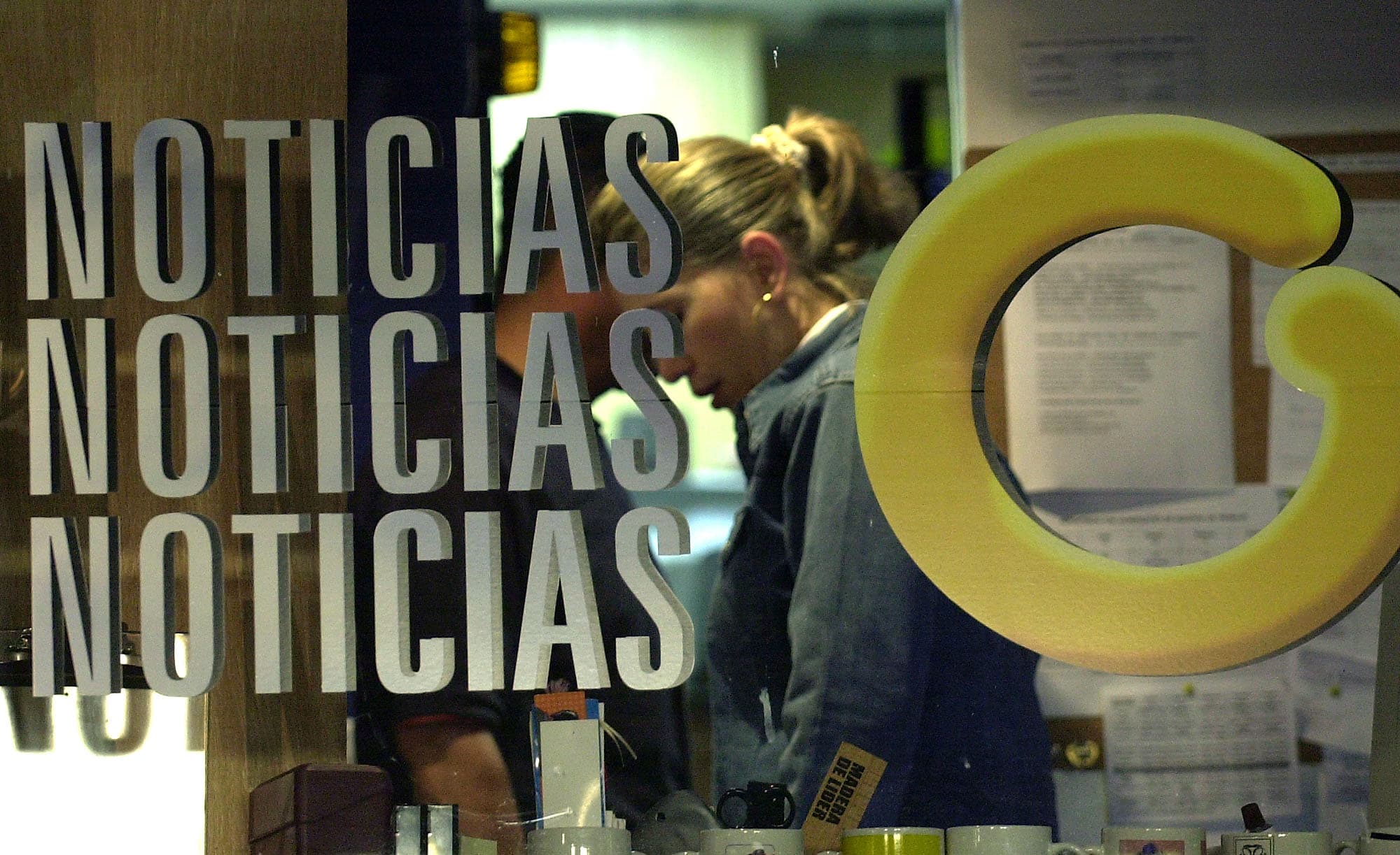 Employee at Globovision works behind a glass reading "News" with Globovision's logo "G", AP Photo/Leslie Mazoch, File