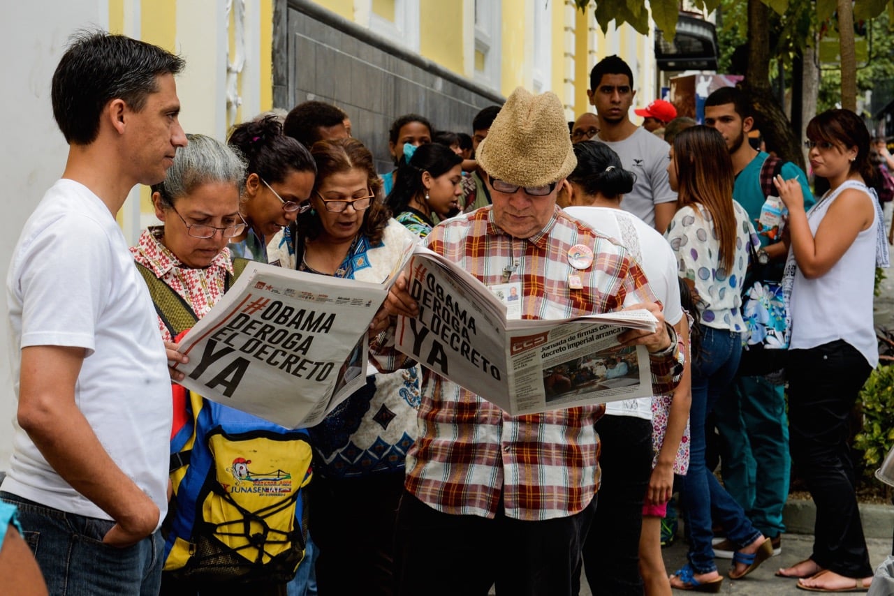 People read newspapers in a line up in Caracas, Venezuela, 19 March 2015, FEDERICO PARRA/AFP/Getty Images