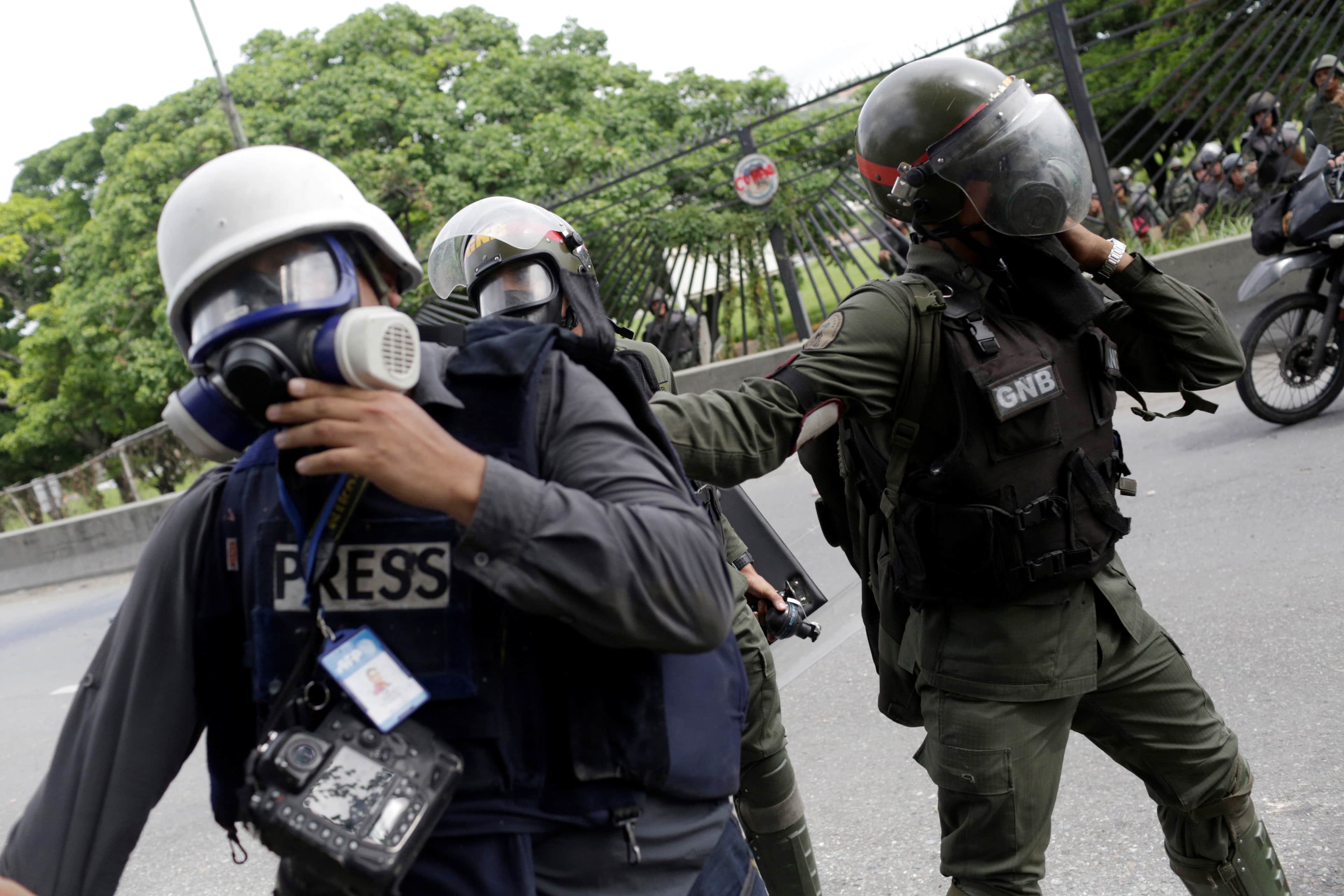 Riot security forces scuffle with a photographer during a rally against Venezuela's President Nicolas Maduro in Caracas, REUTERS/Marco Bello