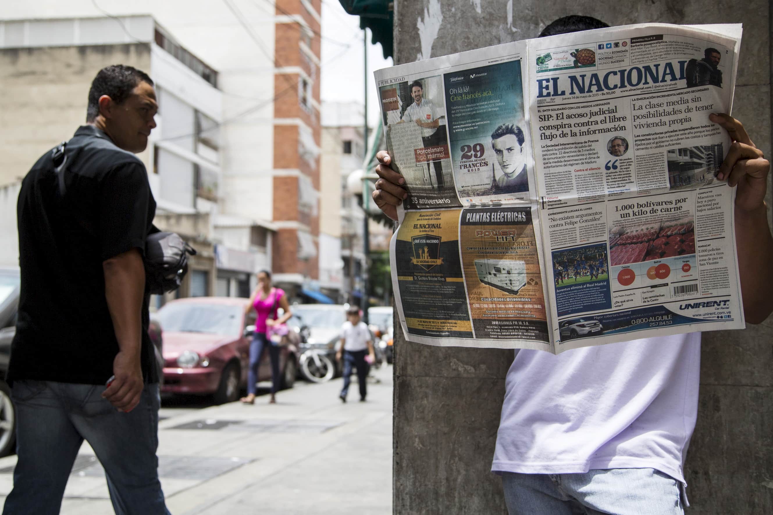 A man reads an "El Nacional" newspaper on a street in Caracas, 14 May 2015, REUTERS/Marco Bello