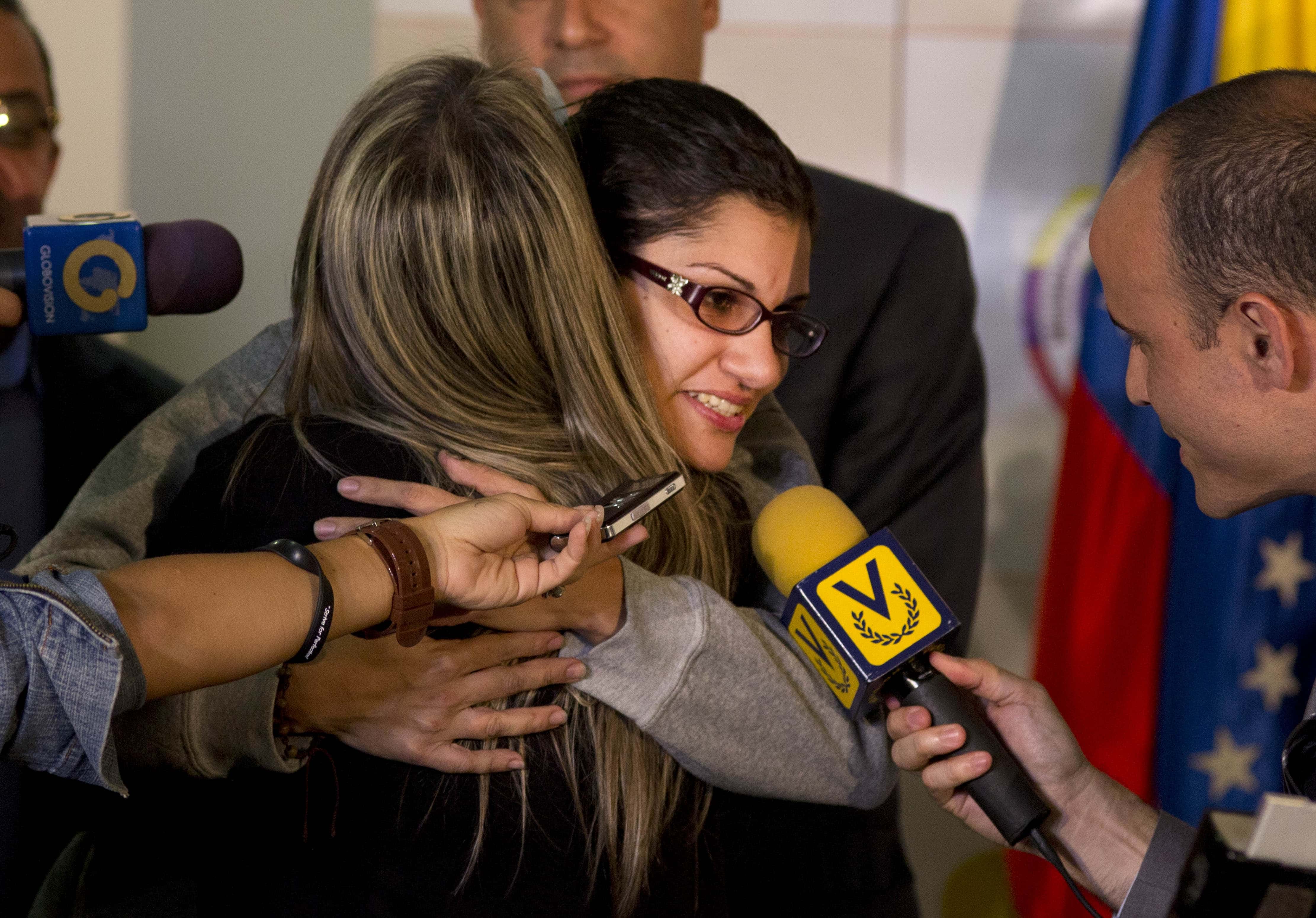 Journalist Nairobi Pinto hugs a colleague as she answers a reporter's question after a press conference following her release from a kidnapping in Caracas, Venezuela, Monday, April 14, 2014, AP Photo/Ramon Espinosa