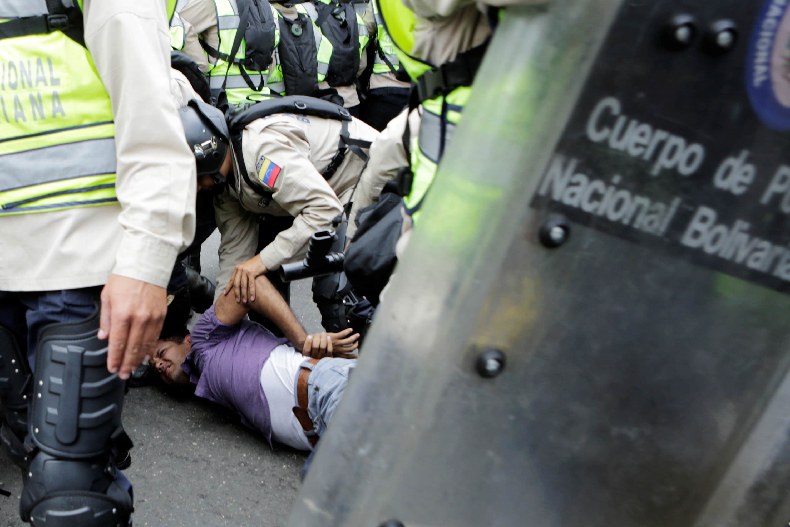 Riot police officers detain a demonstrator during clashes with opposition supporters in Caracas, Venezuela, 18 May 2016, REUTERS/Marco Bello