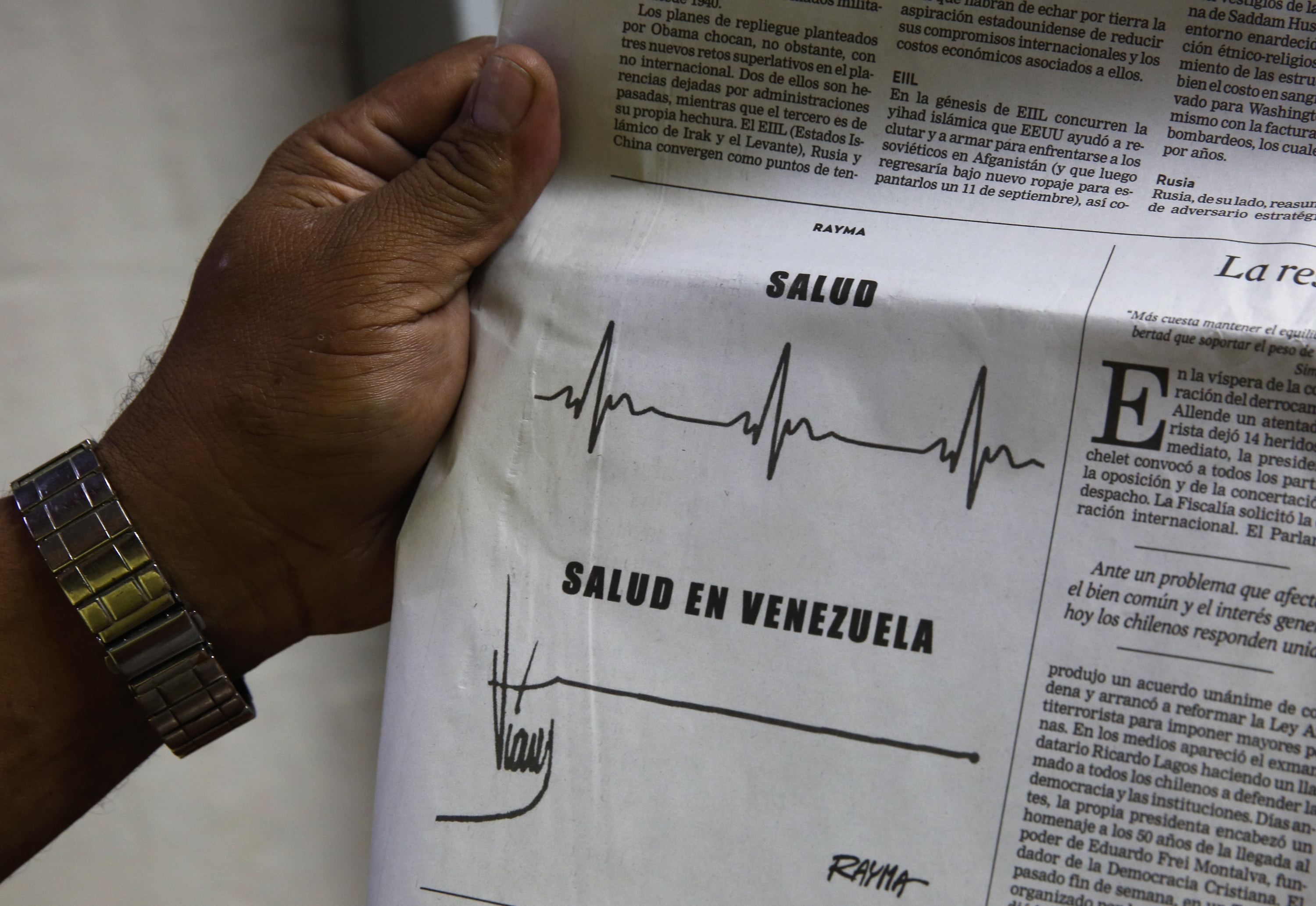 A man shows a cartoon by cartoonist Rayma Suprani, as he holds a newspaper in Caracas September 18, 2014, REUTERS/Carlos Garcia Rawlins