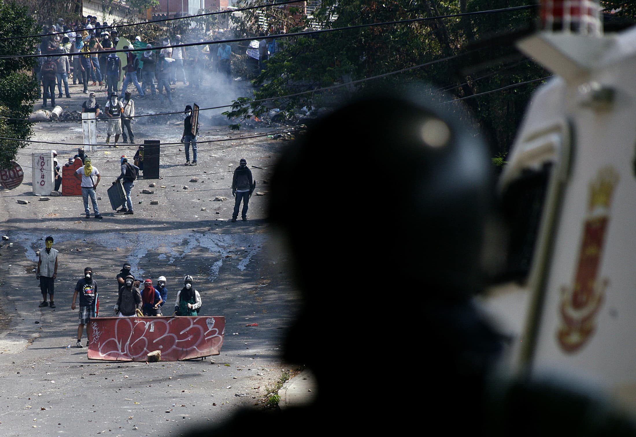 Anti-government protesters clash with a member of the National Guard during a protest in San Cristobal, 18 March 2014., REUTERS/Carlos Eduardo Ramirez