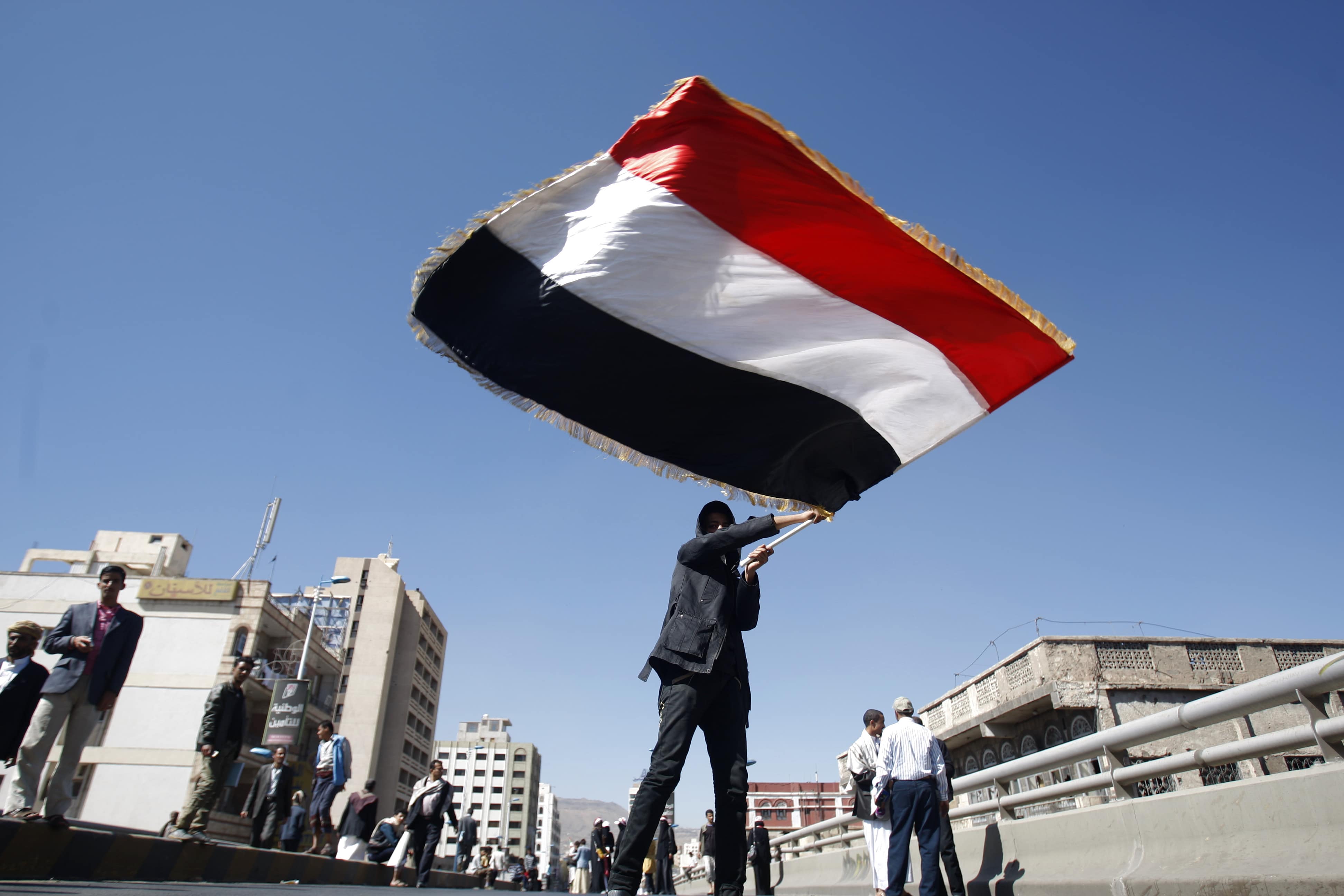 A Yemeni protester waves his national flag during a demonstration, AP Photo/Hani Mohammed