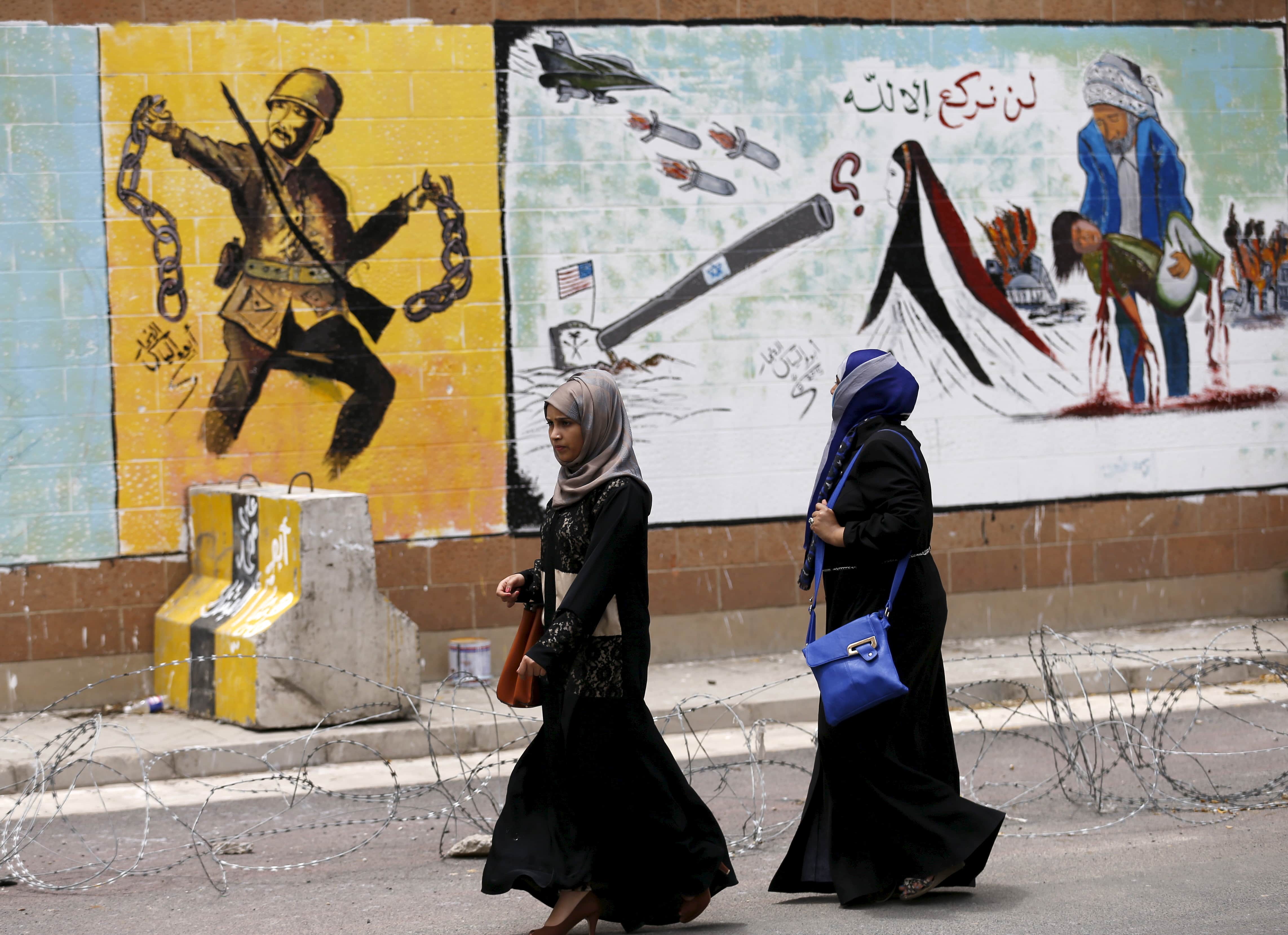 Women walk past graffiti painted by pro-Houthi activists on the wall of the Saudi embassy in Yemen's capital Sanaa August 18, 2015, REUTERS/Khaled Abdullah