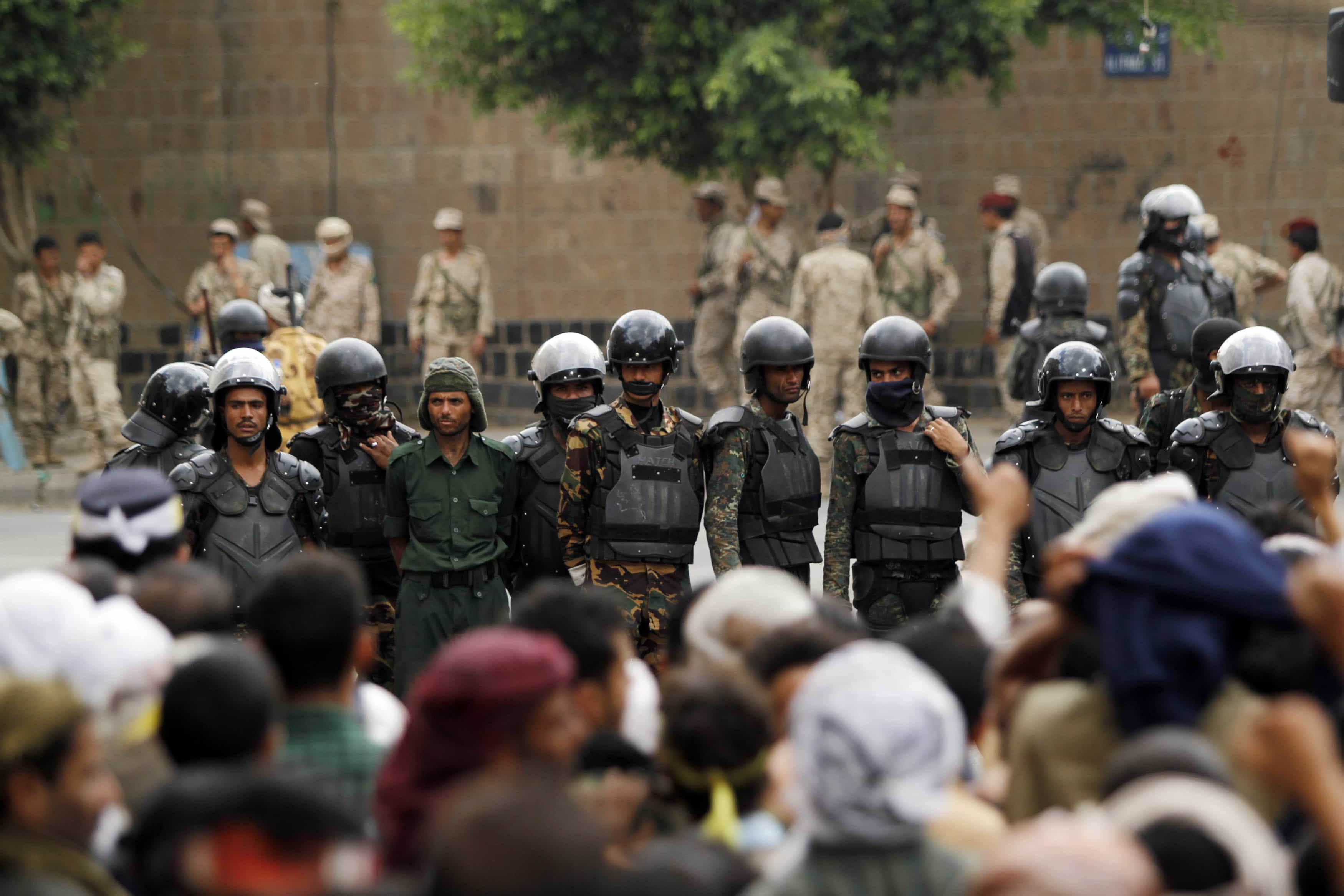 Followers of the Shi'ite Houthi movement stand in front of riot police near the cabinet building in Sanaa on 9 September 2014, REUTERS/Mohamed al-Sayaghi