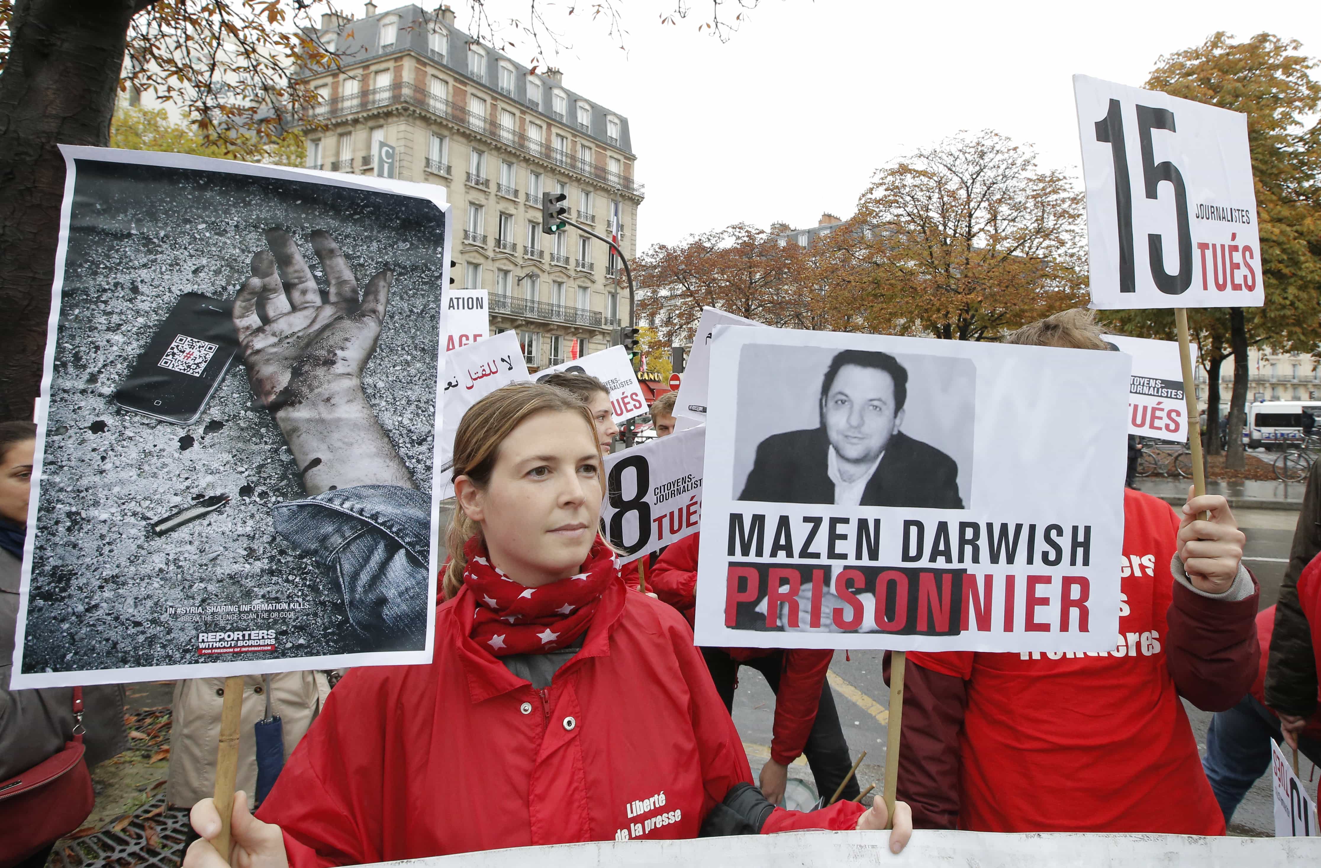 Lucie Morillon, head of research at Reporters without Borders holds a banner depicting Syrian human rights activist Mazen Darwish during a protest against violence in Syria, in Paris, on 20 October 2012, AP Photo/Francois Mori