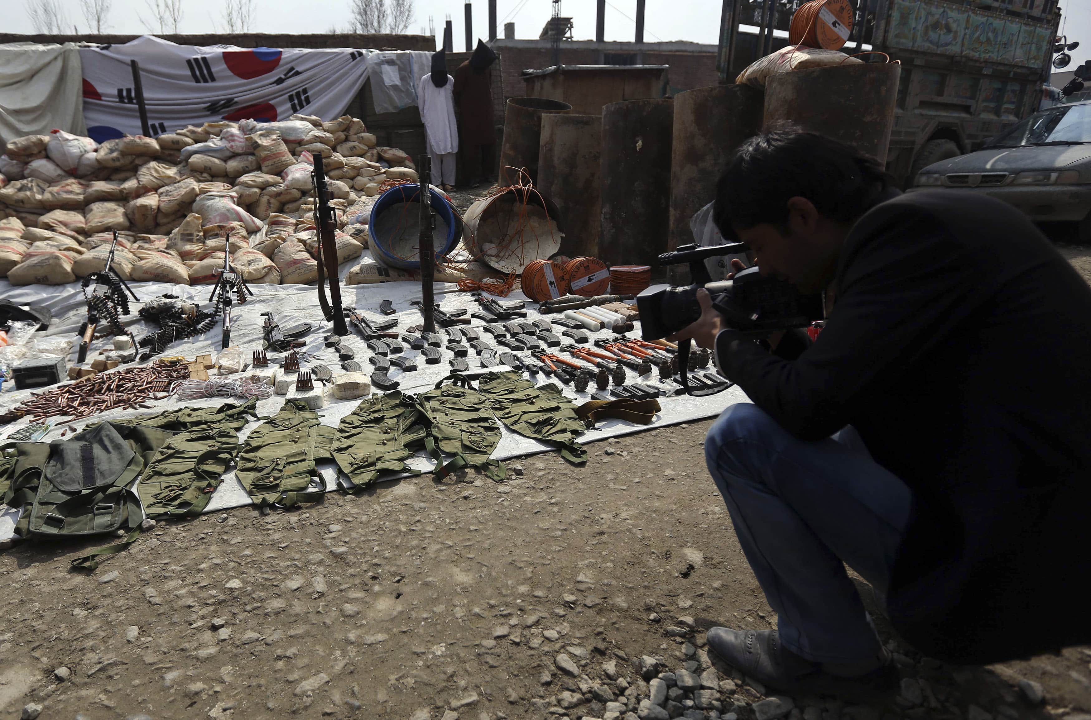 An Afghan cameraman films the weapons and ammunition seized from captured suspected Taliban and presented to the media in Kabul, 15 March 2013, REUTERS/Omar Sobhani