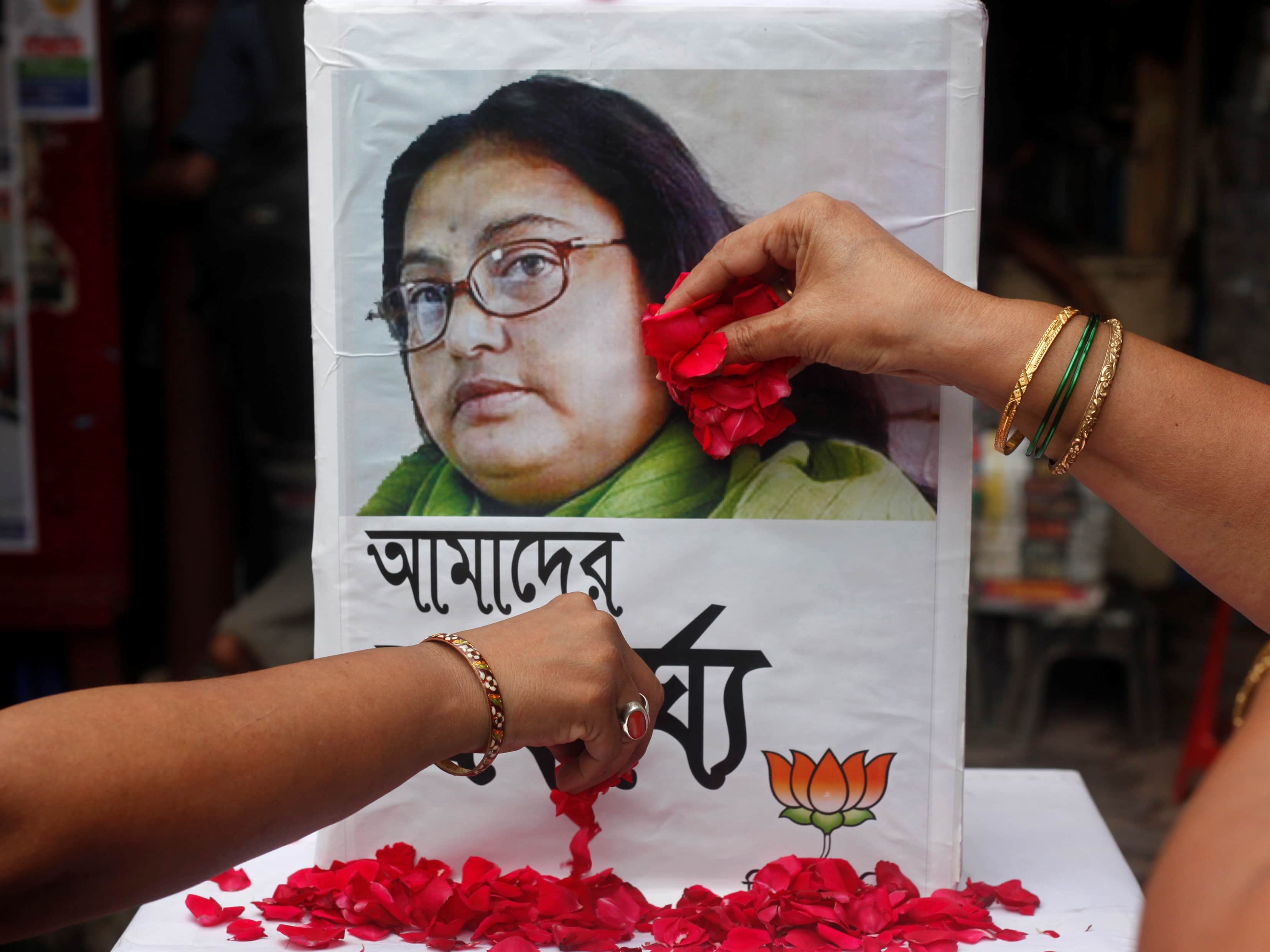 Supporters of India's main opposition Hindu nationalist Bharatiya Janata Party (BJP) women's wing, scatter rose petals in front of a portrait of slain author Sushmita Banerjee, in Kolkata, 7 September 2013, REUTERS/Rupak De Chowdhur