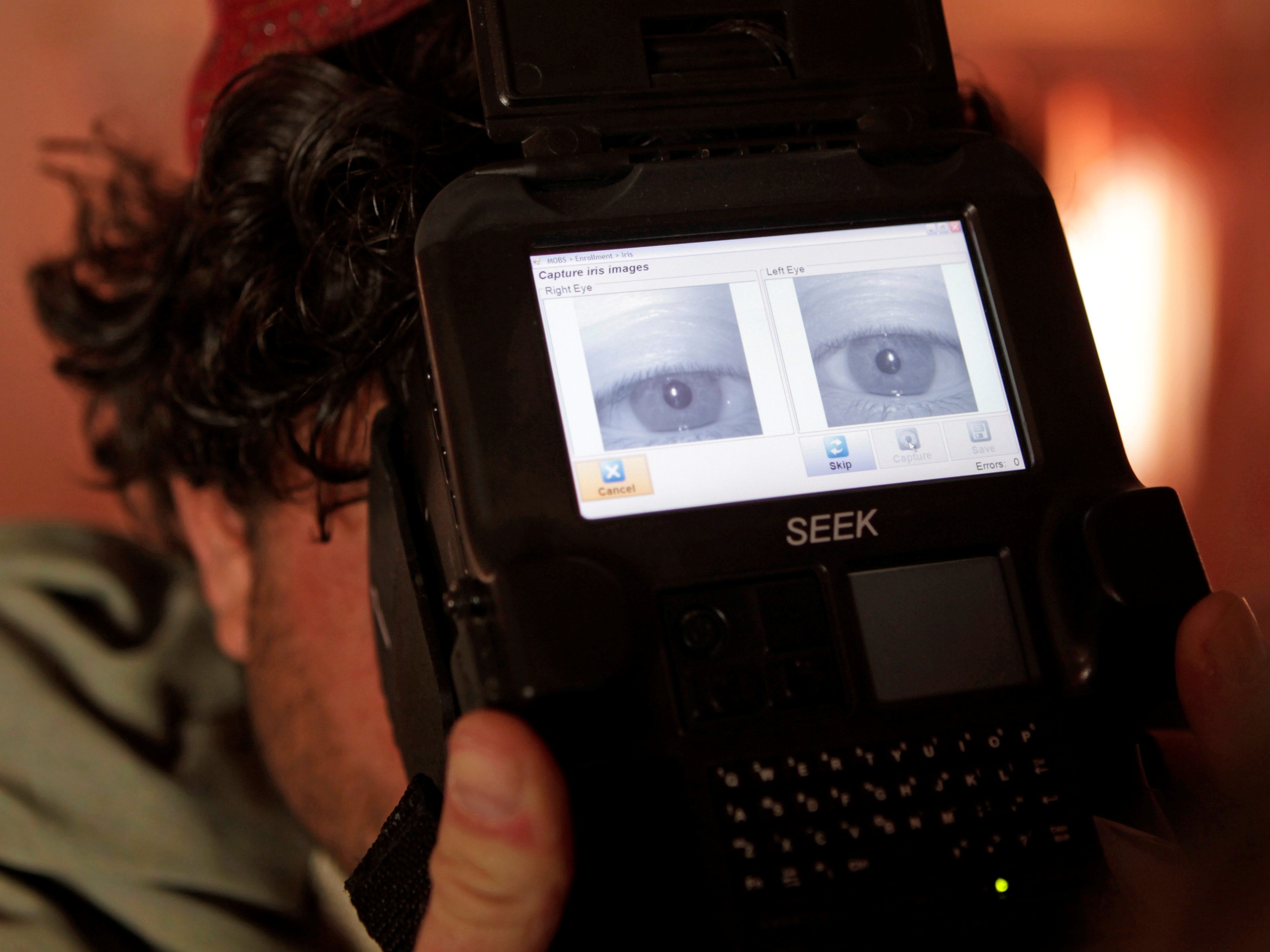 A US Army soldier takes a biometric scan of an Afghan police officer before paying his monthly salary, in Kandahar province, Afghanistan, October 2012, REUTERS/Erik De Castro