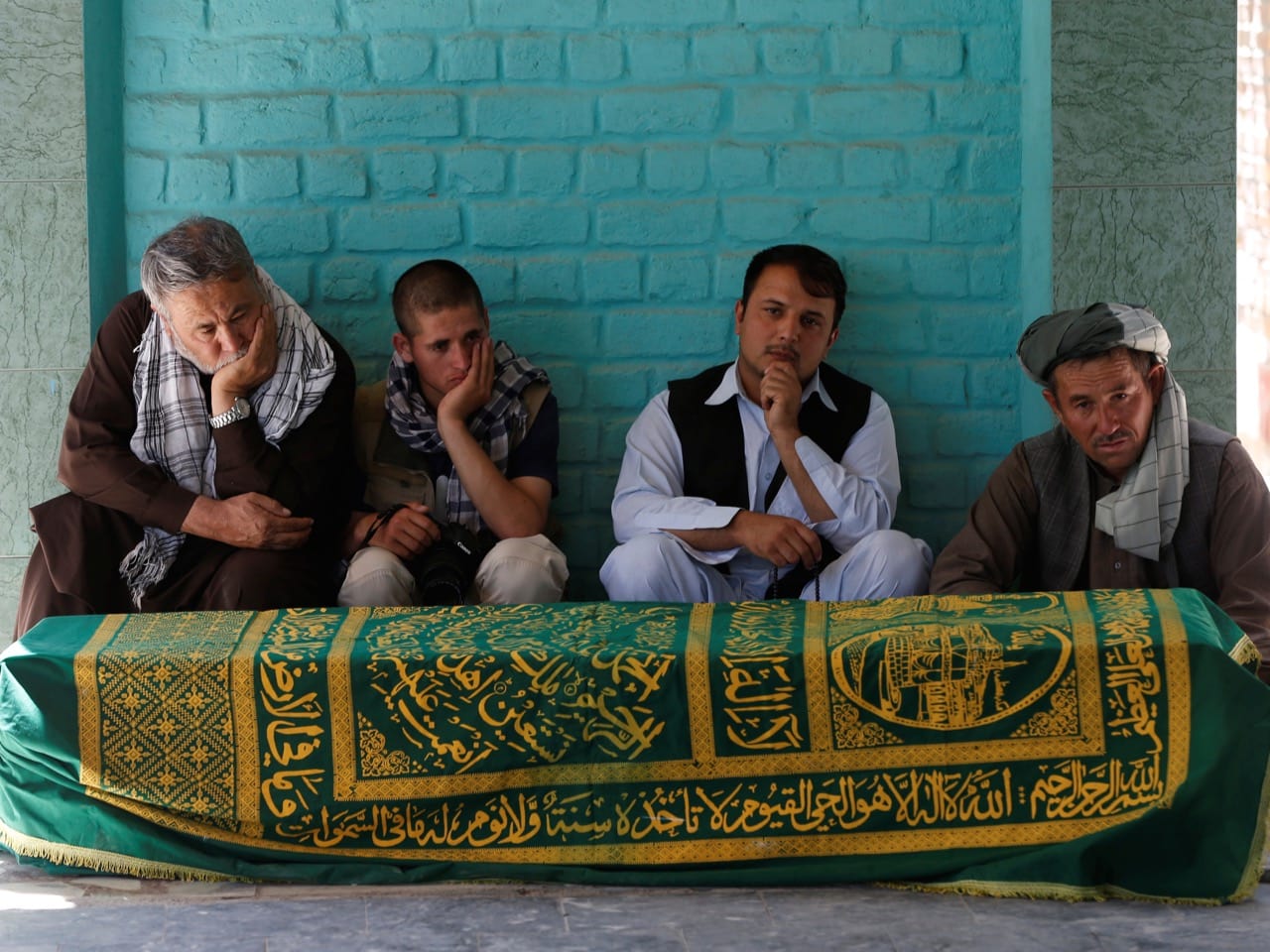 Afghans sit beside the coffin of journalist Zabihullah Tamanna, before a burial ceremony, in Kabul, Afghanistan 7 June 2016, REUTERS/Omar Sobhani