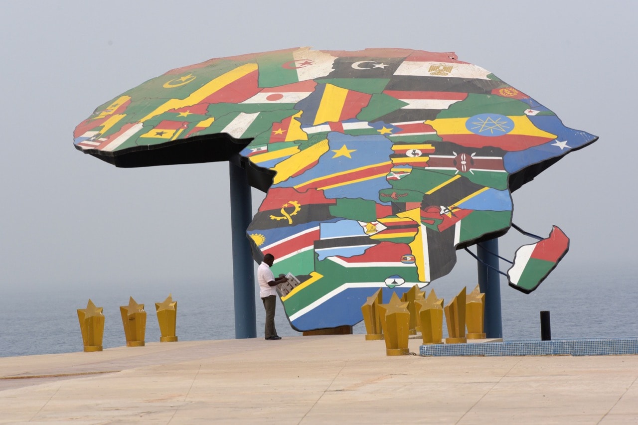 A man reads a newspaper in front a map of Africa at the Place du Souvenir Africain, in Dakar, Senegal, 27 January 2016, SEYLLOU/AFP/Getty Images