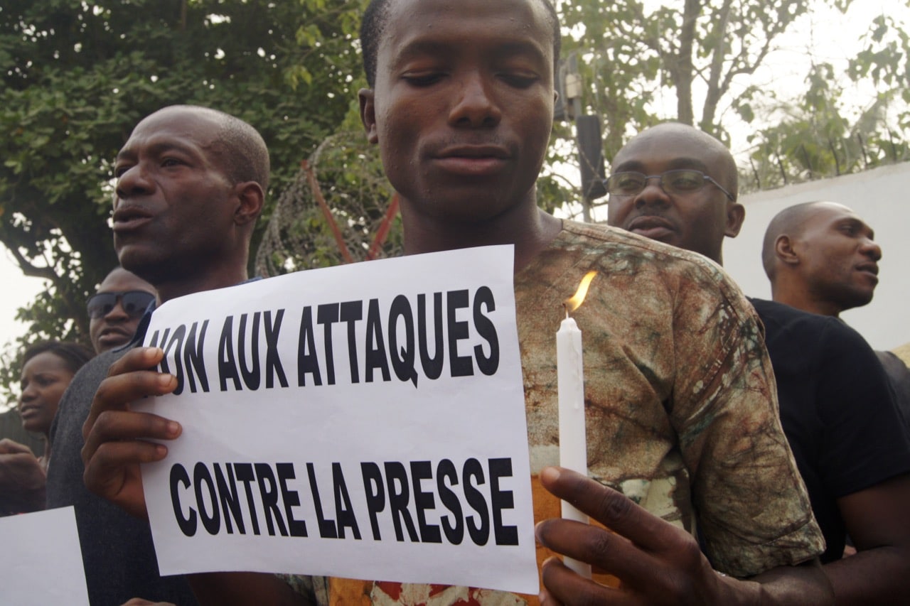 A Togolese journalist holds a sign reading in French 'No to attacks against the press' during a gathering in Lome, 8 January 2015, EMILE KOUTON/AFP/Getty Images